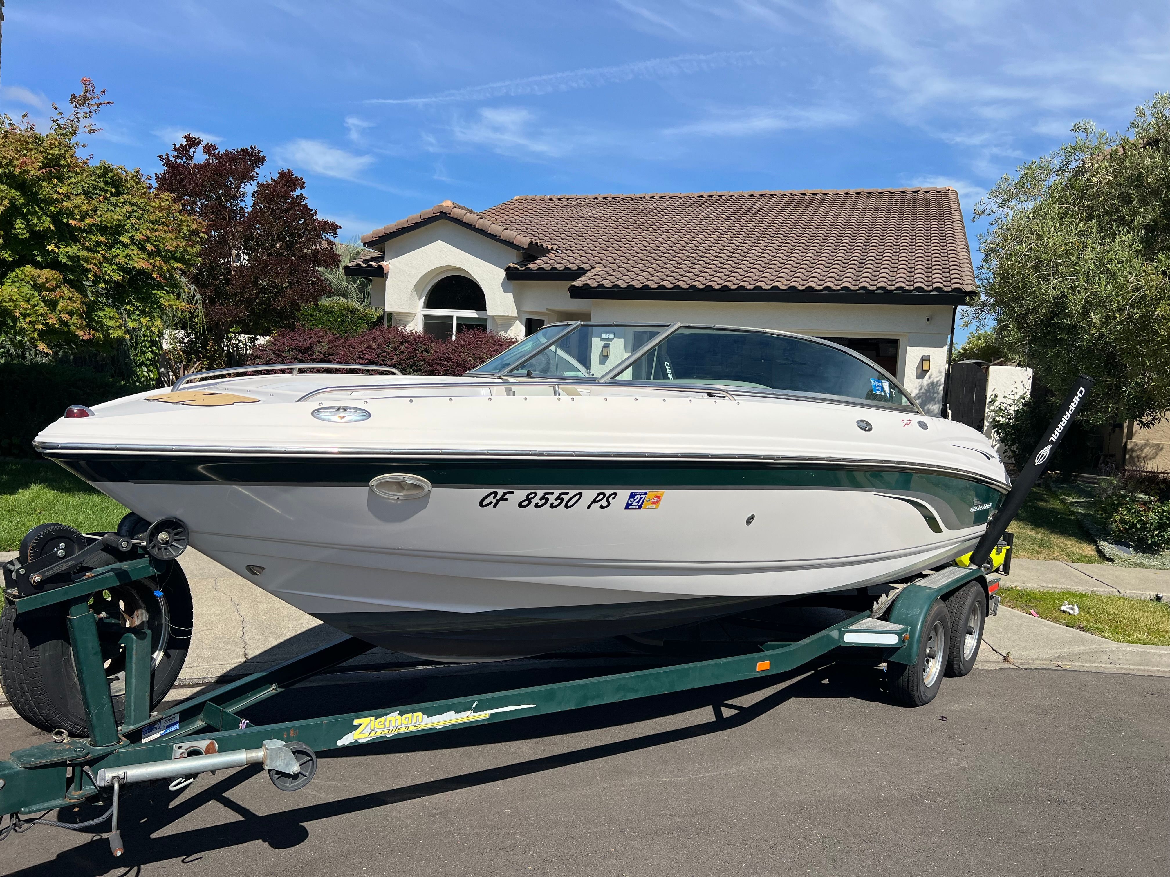 2001 Chaparral 216 SSi boat on trailer in front of house.