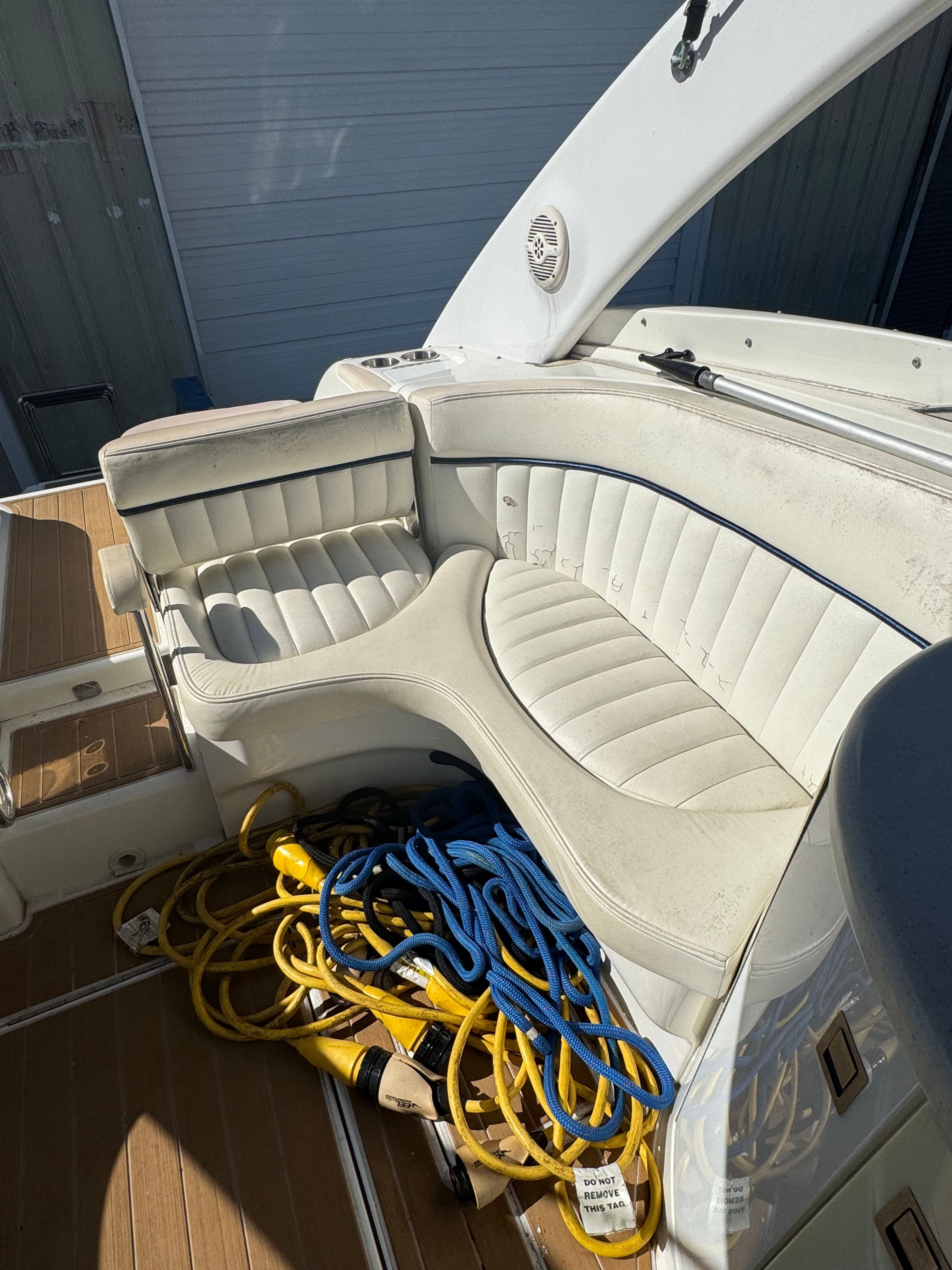 The image shows the cockpit of a 2003 Cobalt 360 boat with white leather seating.