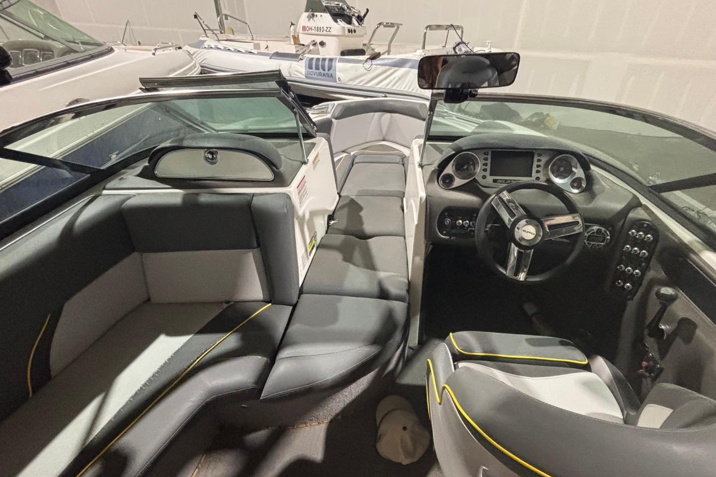 2012 Supra Sunsport 21 V boat interior with sleek seating and modern dashboard design.