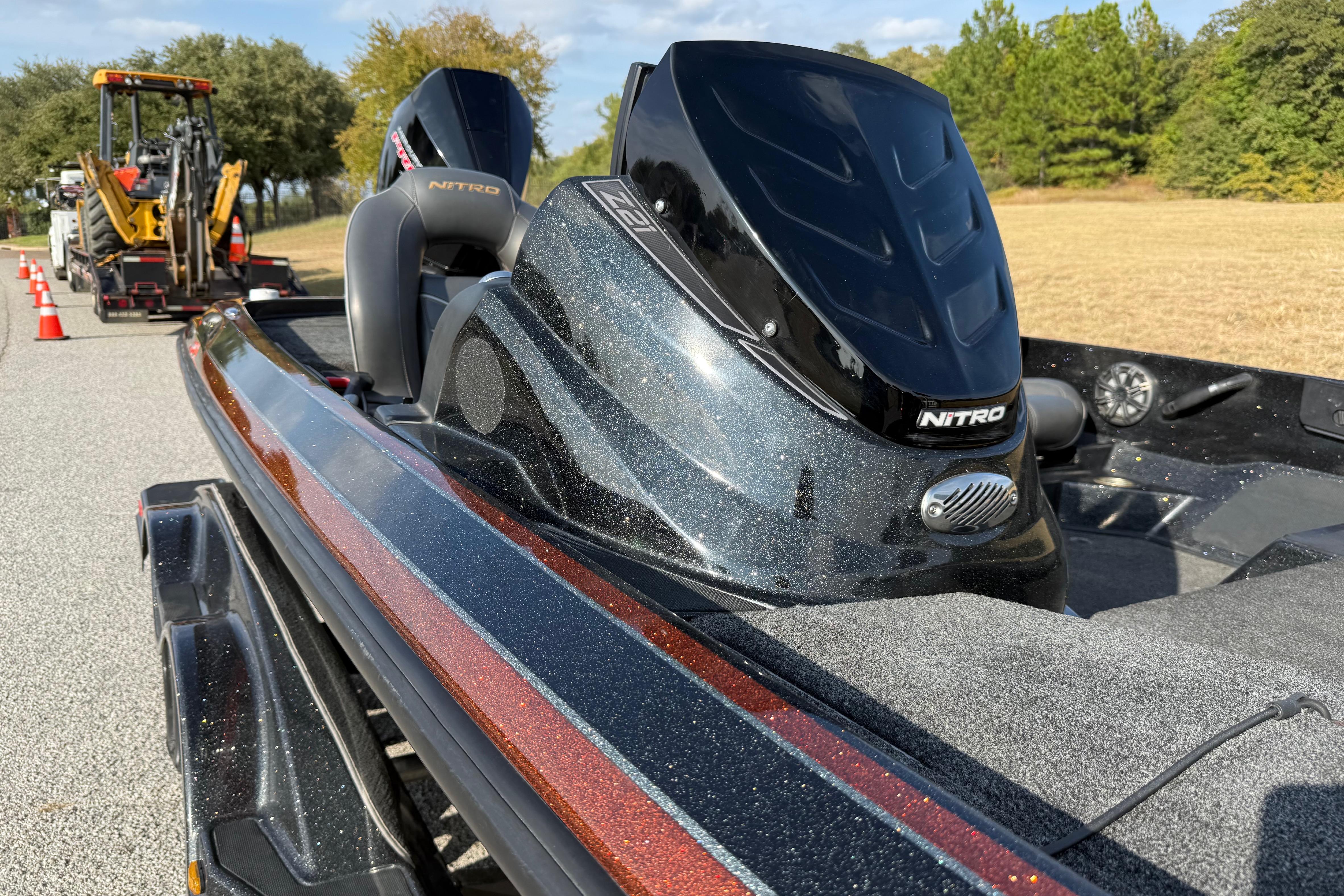 2019 Nitro Z21 Pro boat on trailer, parked on road with construction equipment nearby.