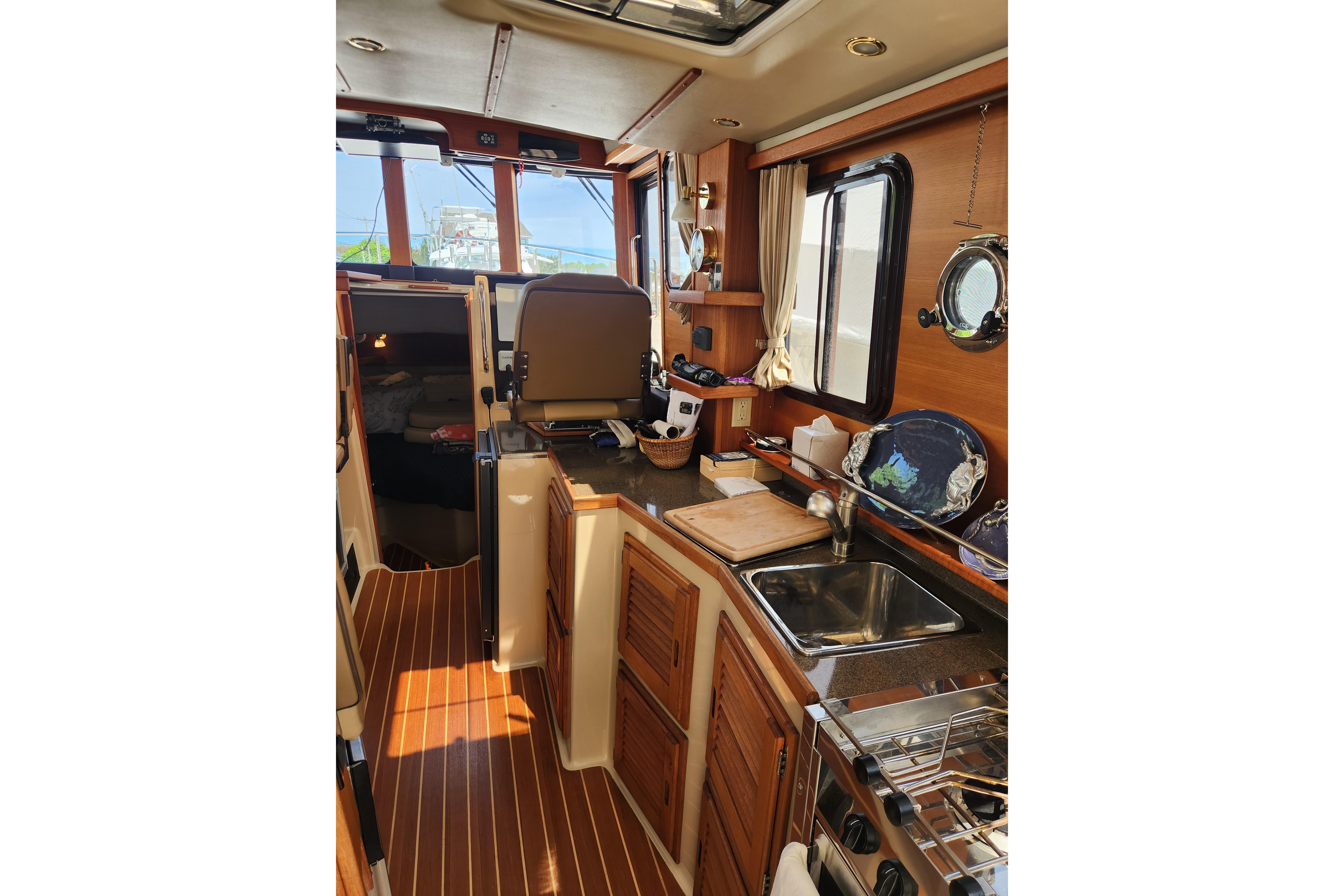 Interior of 2019 Ranger Tugs R-31 CB, featuring a well-equipped kitchen and helm station.