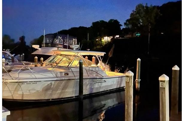 2000 Pursuit 3400 Express boat docked at night, illuminated by soft lighting.