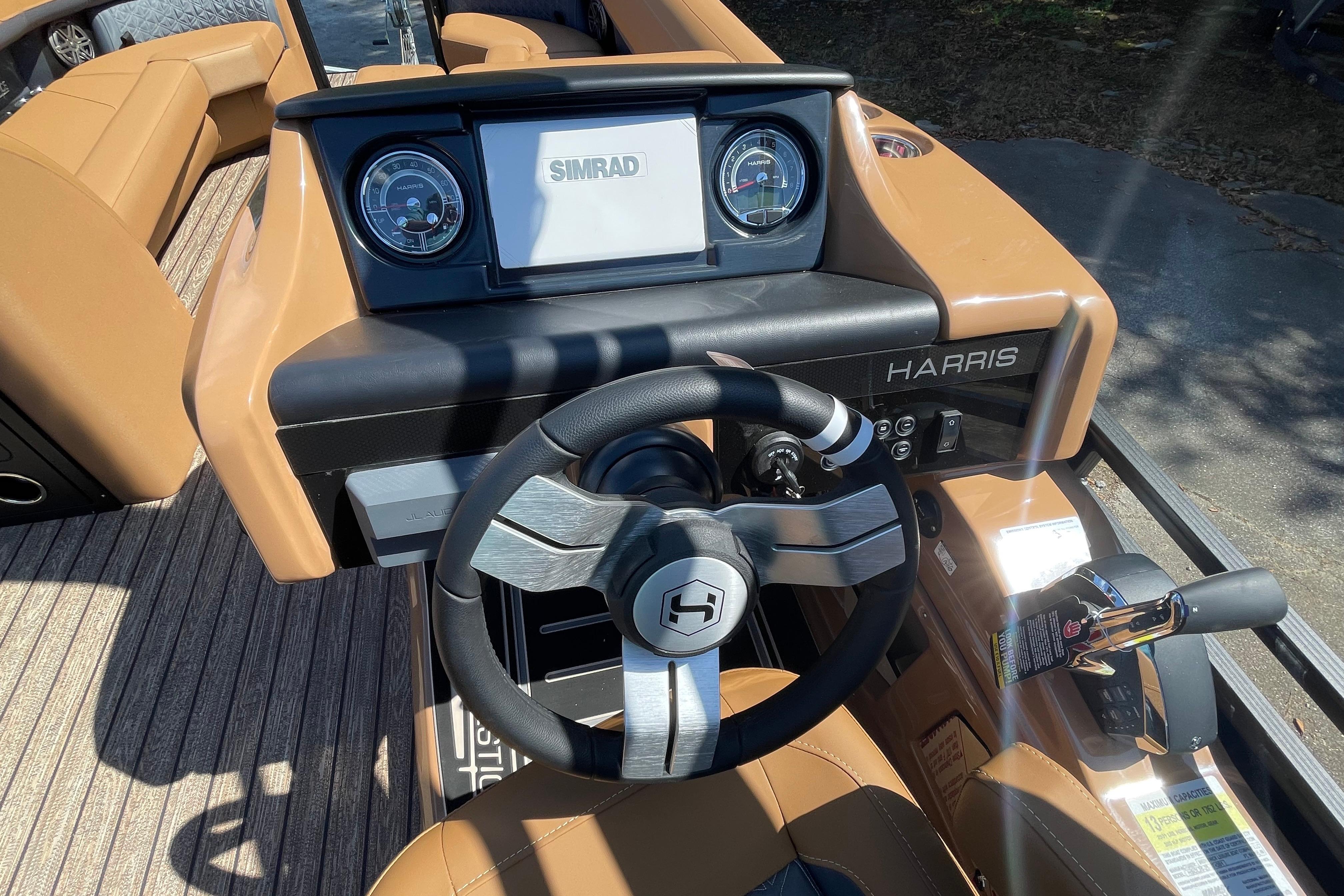 2026 Harris Solstice 250 SLDH boat dashboard with steering wheel and Simrad display.
