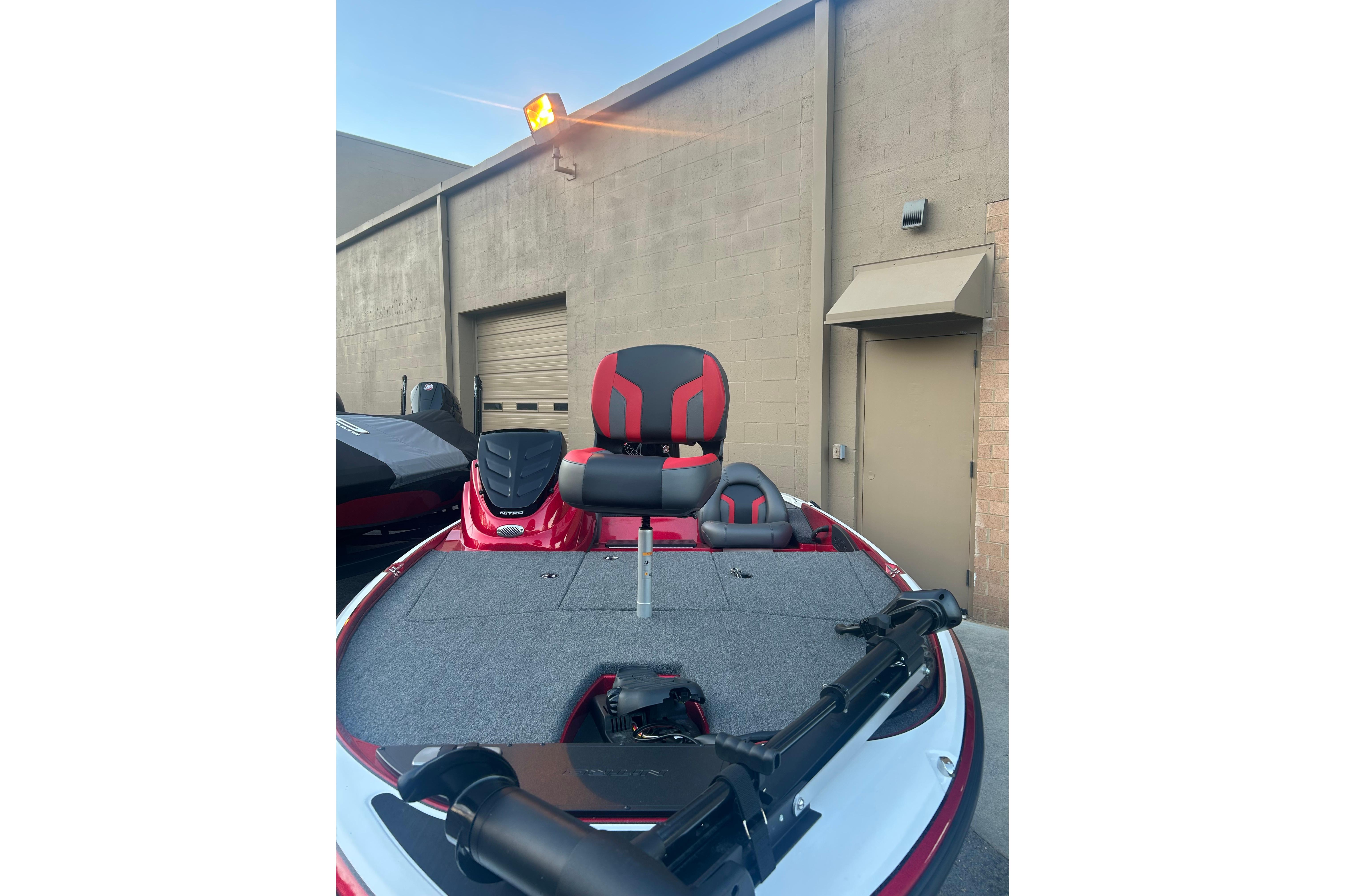 2026 Nitro Z17 boat with red and black seating, parked near a building.