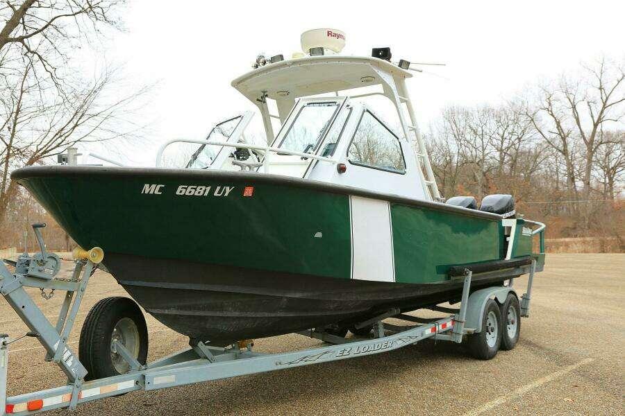 2002 SeaArk 25 V Commander SAMA 1365 boat on trailer, parked outdoors.