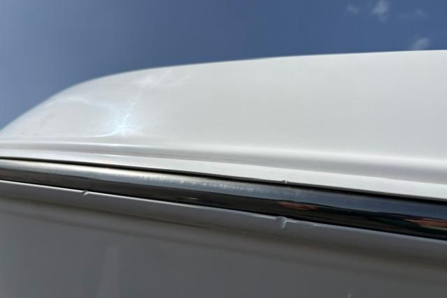 2024 Tahoe T21 vehicle roof detail with chrome trim against blue sky.