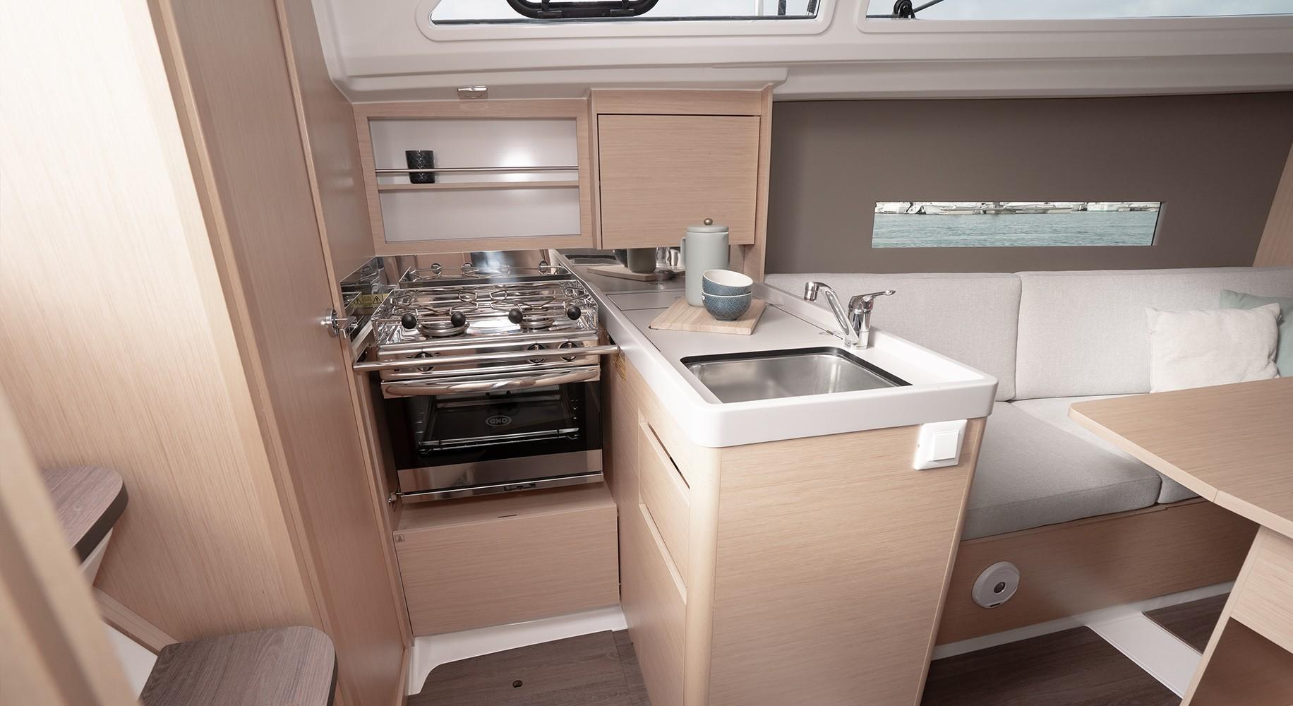 Interior of 2025 Beneteau Oceanis 30.1 yacht, featuring a compact kitchen and seating area.