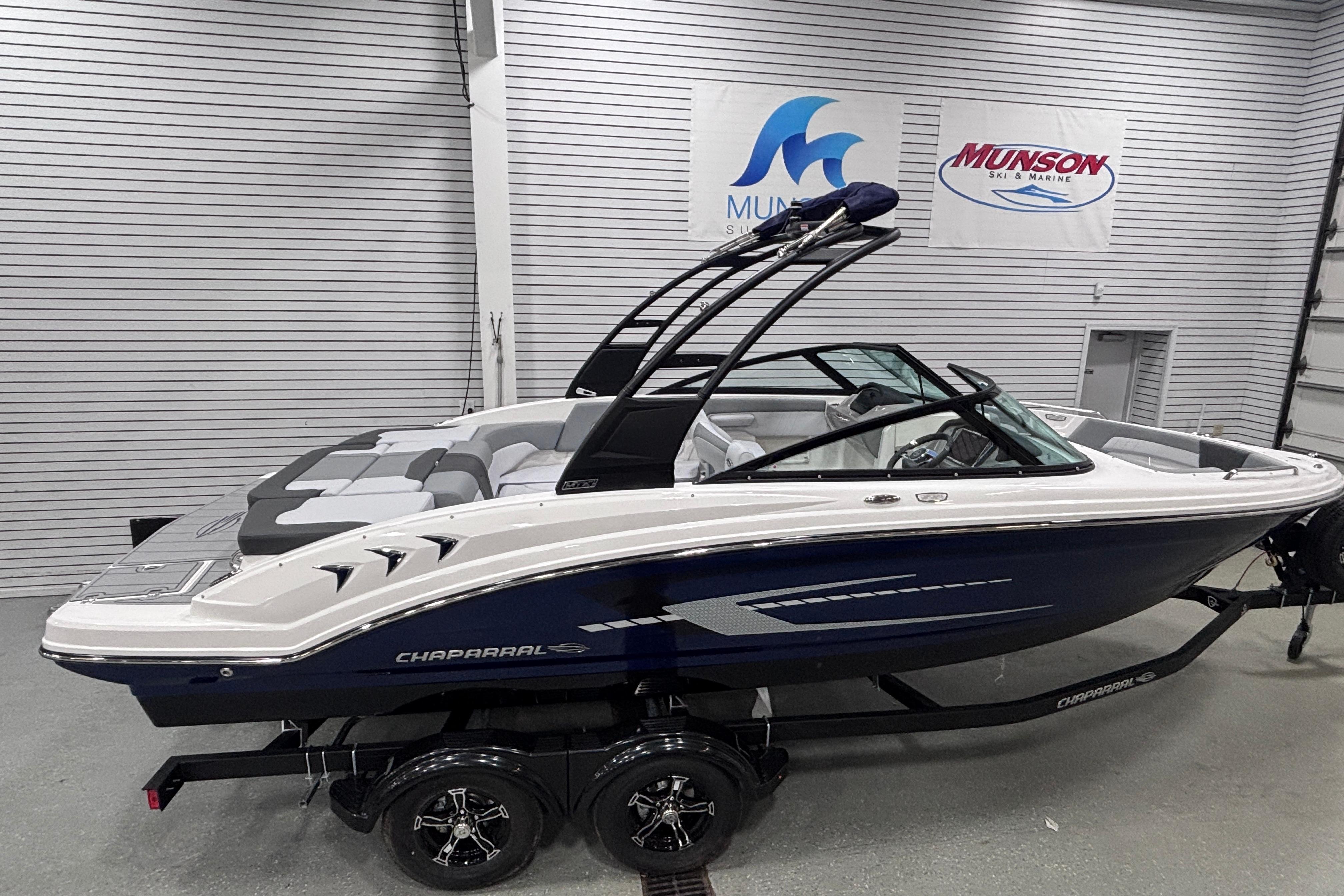 2026 Chaparral 23 SSi boat in showroom, side view with sleek design and modern features.