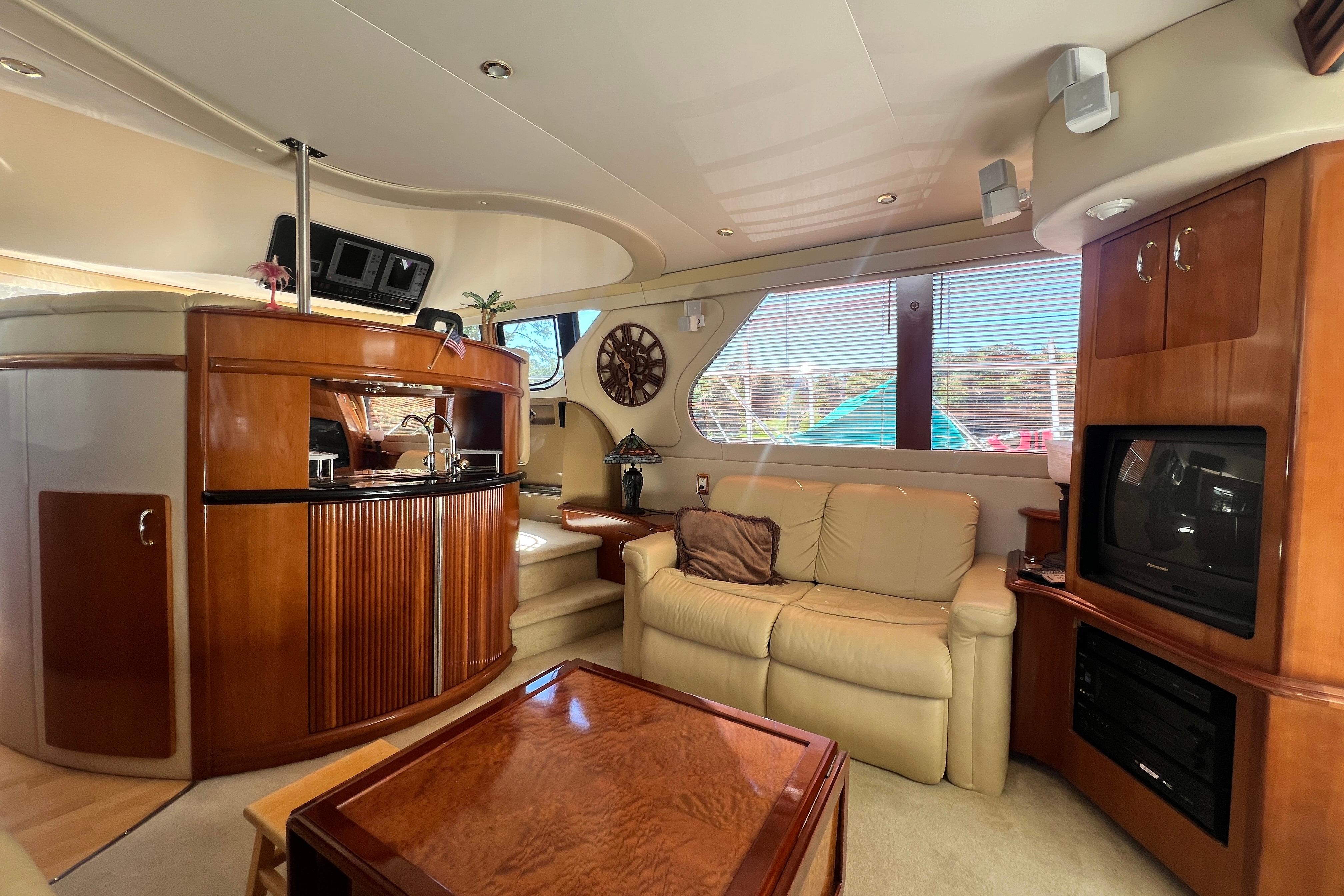 Luxurious interior of 2003 Carver 450 Voyager Pilothouse with elegant wood finishes and cozy seating.
