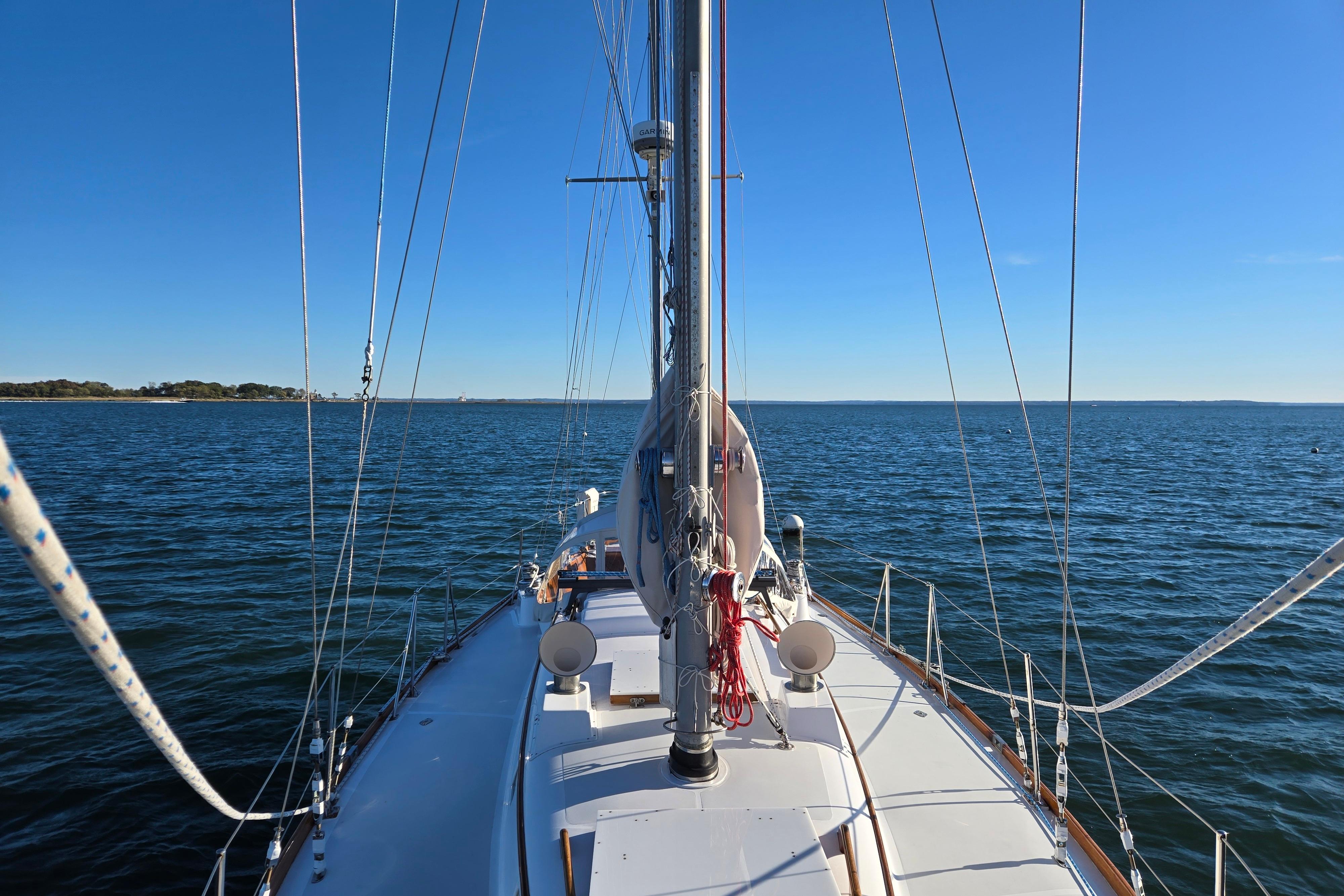 Sailing on a 1970 Hinckley Bermuda 40 yacht under clear blue skies.