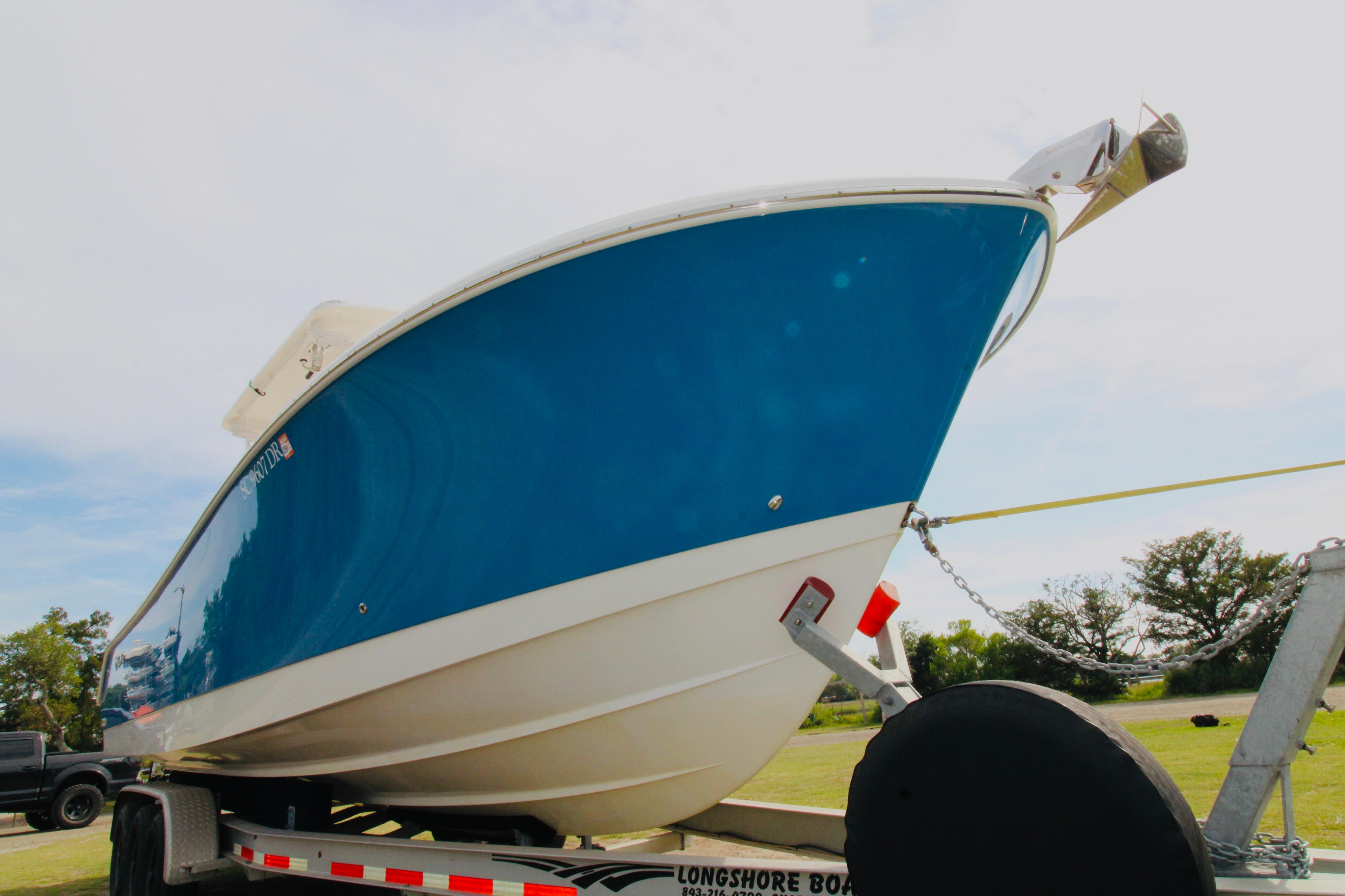 2022 Edgewater 280CC boat on trailer, blue hull, outdoors.