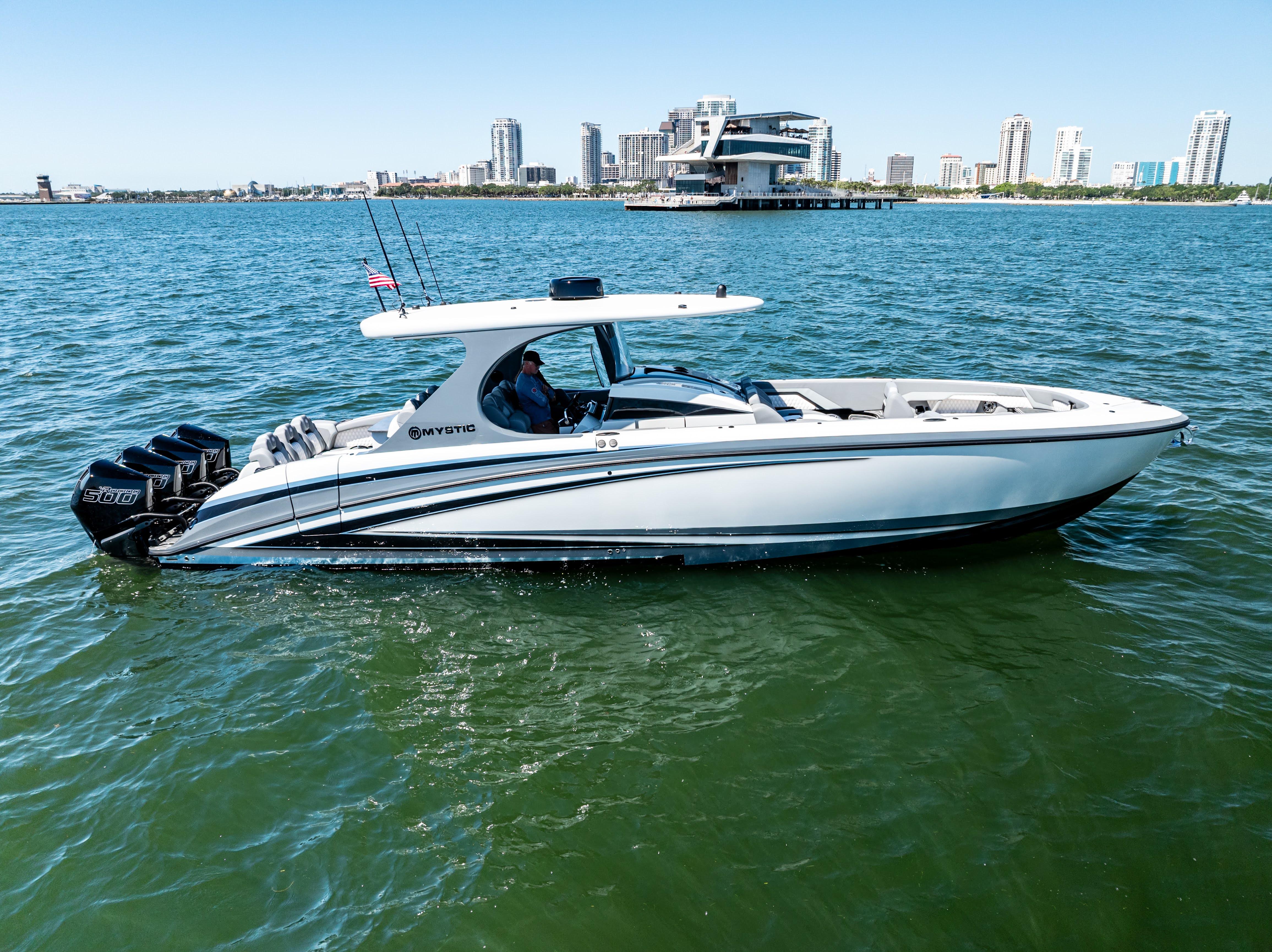 2026 Mystic Powerboats M4200 cruising on water with city skyline in background.