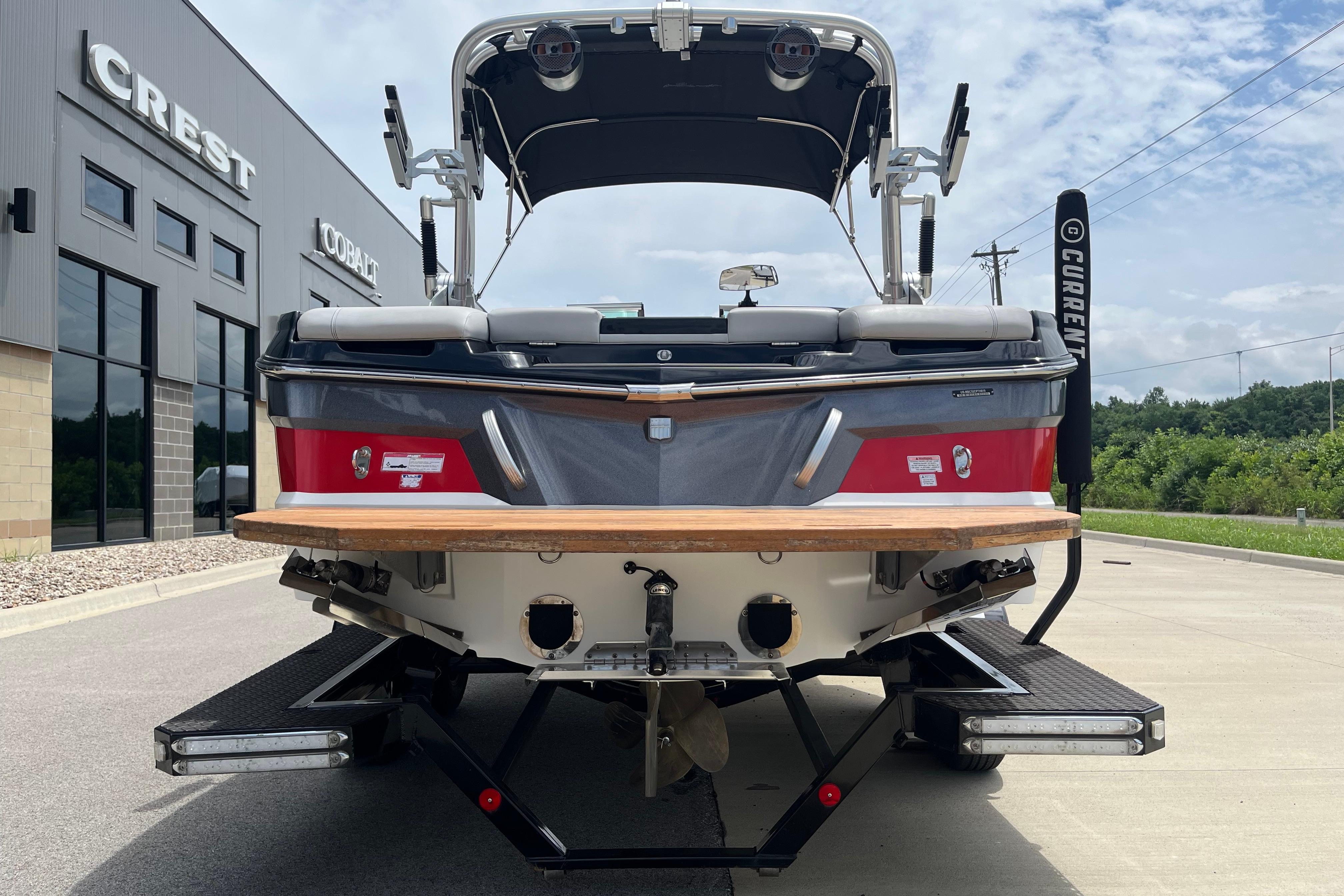 2019 MasterCraft XT20 boat, rear view, parked near dealership buildings.