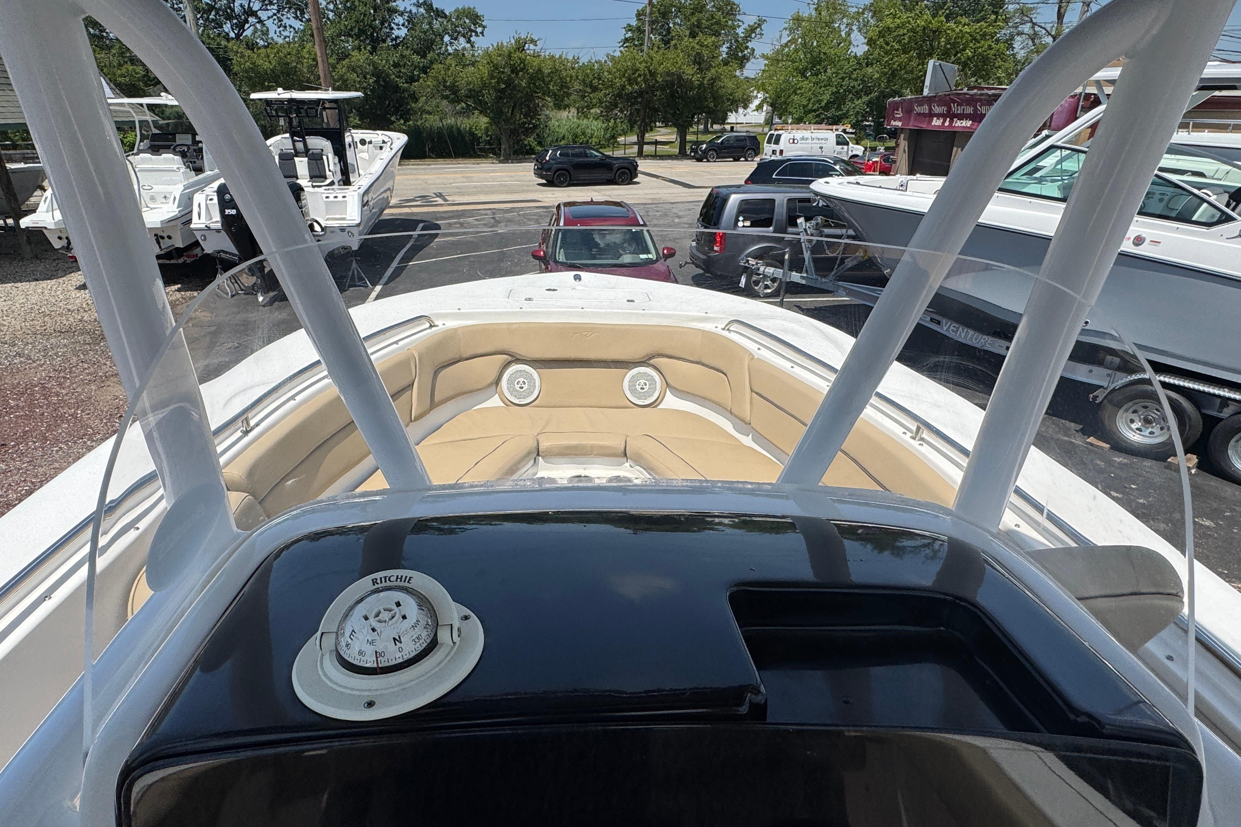 2016 Tidewater 230 LXF boat interior with compass, parked in a marina.