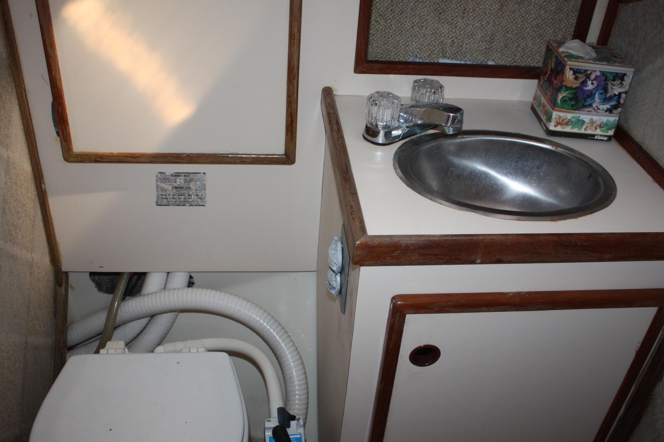 Compact bathroom in 1981 S2 9.2A sailboat with sink and toilet.