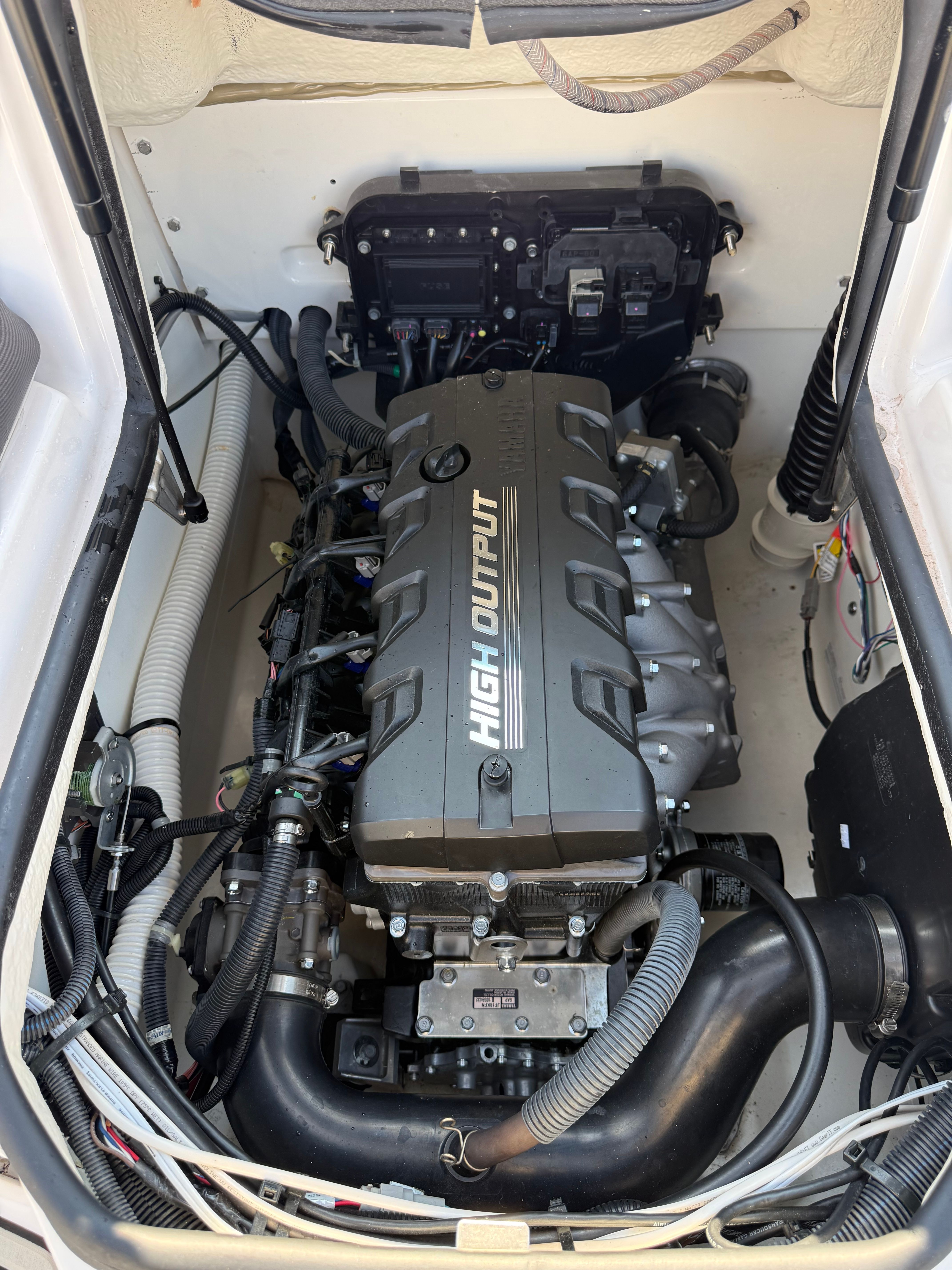 The engine compartment of a 2023 Yamaha AR190 boat features a high-output engine with various hoses.