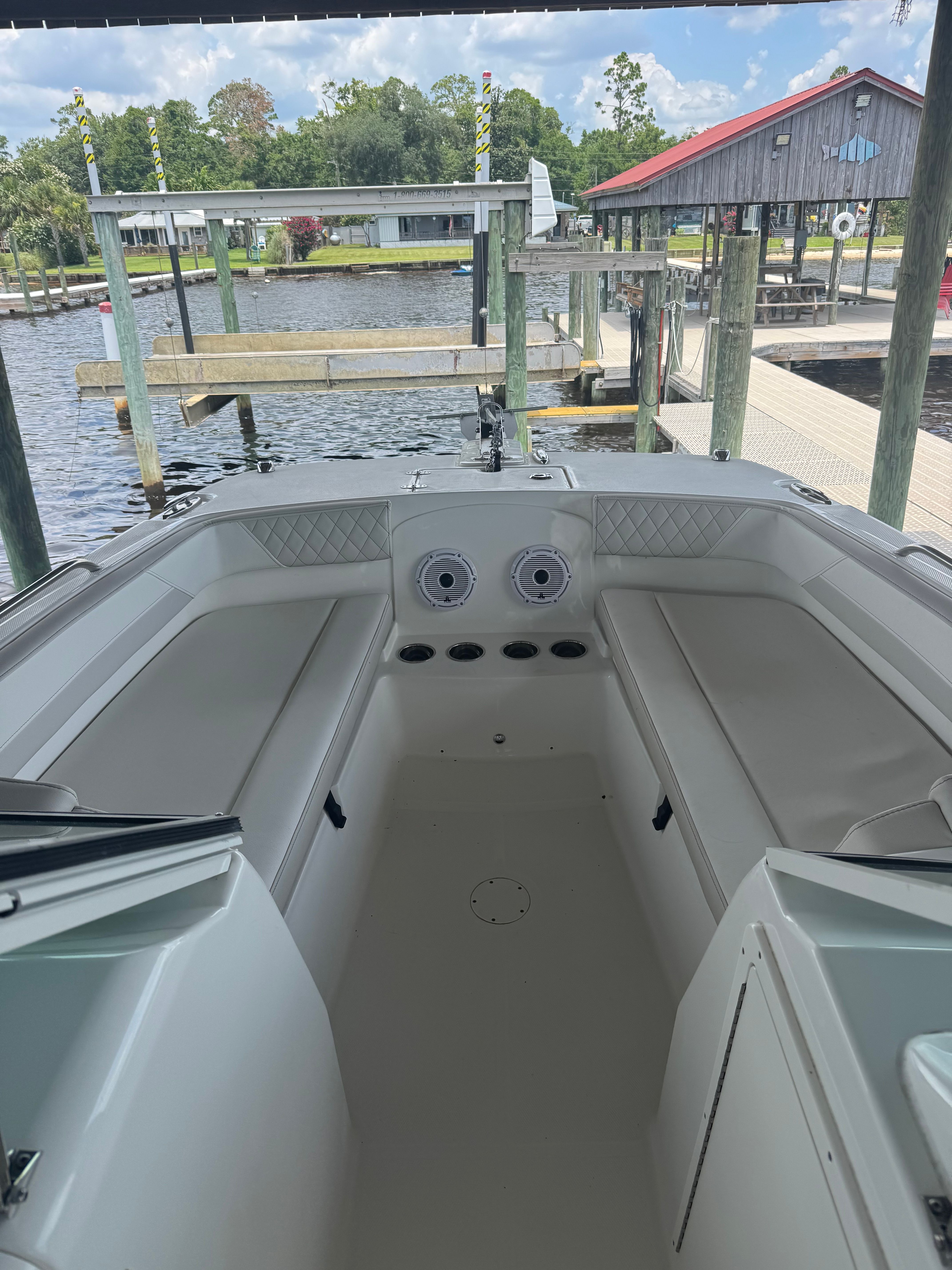 The image shows the cockpit of a 2025 World Cat 230 DC boat docked at a pier.