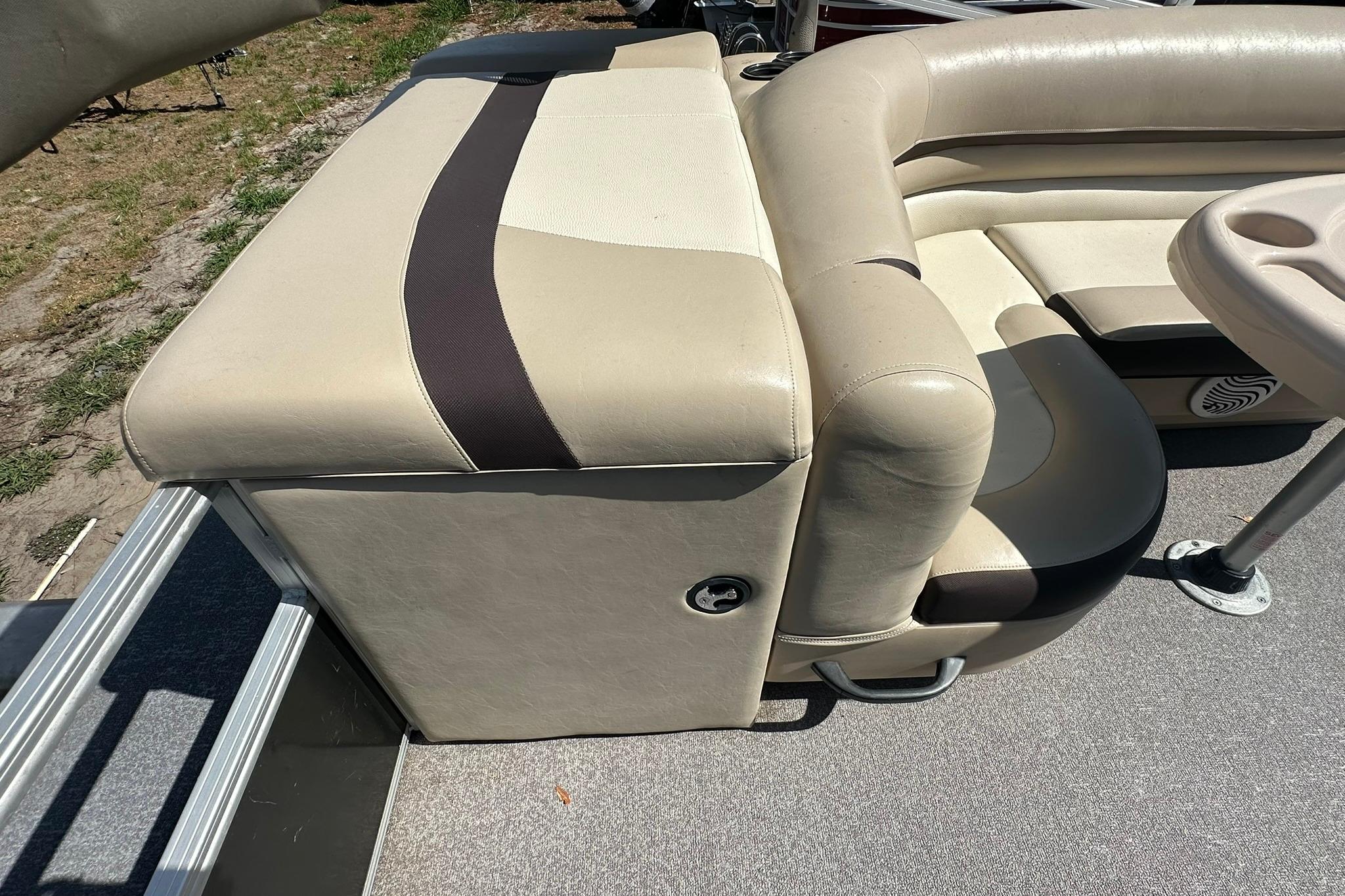 2016 SUNTRACKER Party Barge 20 interior seating with beige upholstery and cup holders.