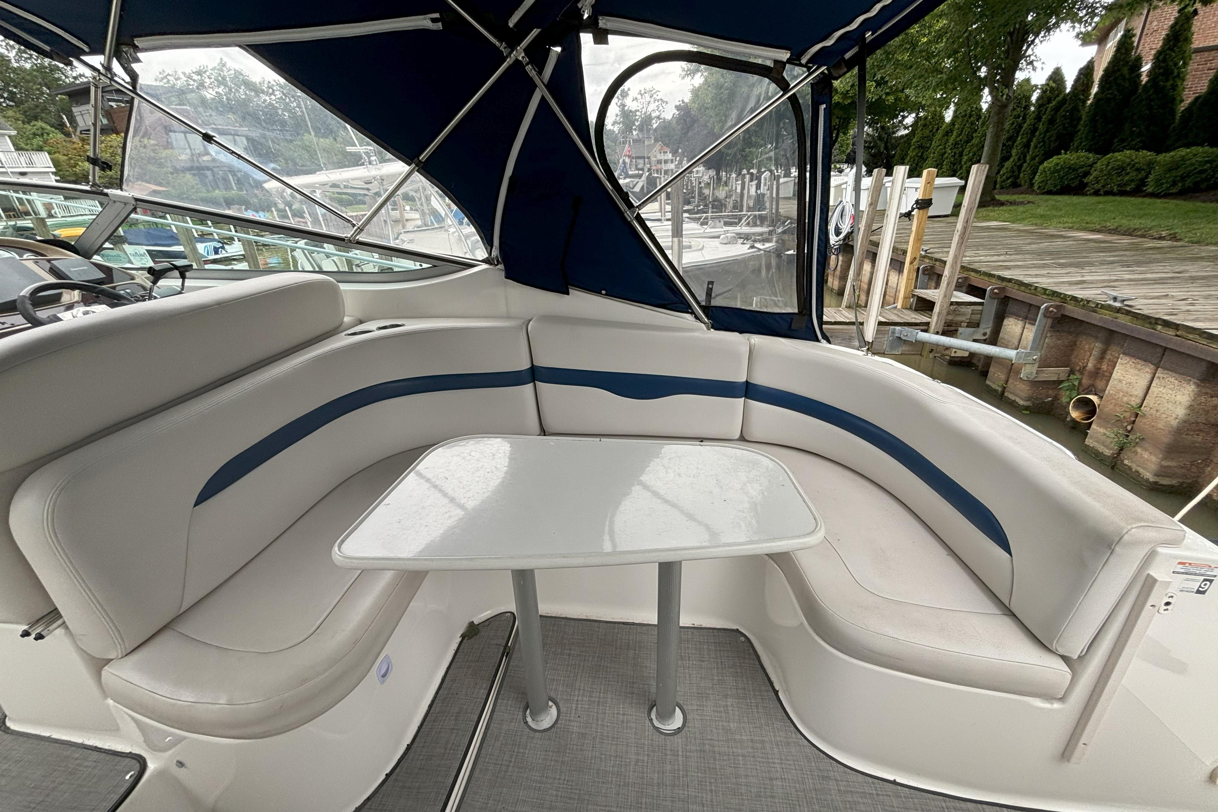 2003 Chaparral 310 Signature boat interior with cushioned seating and table.