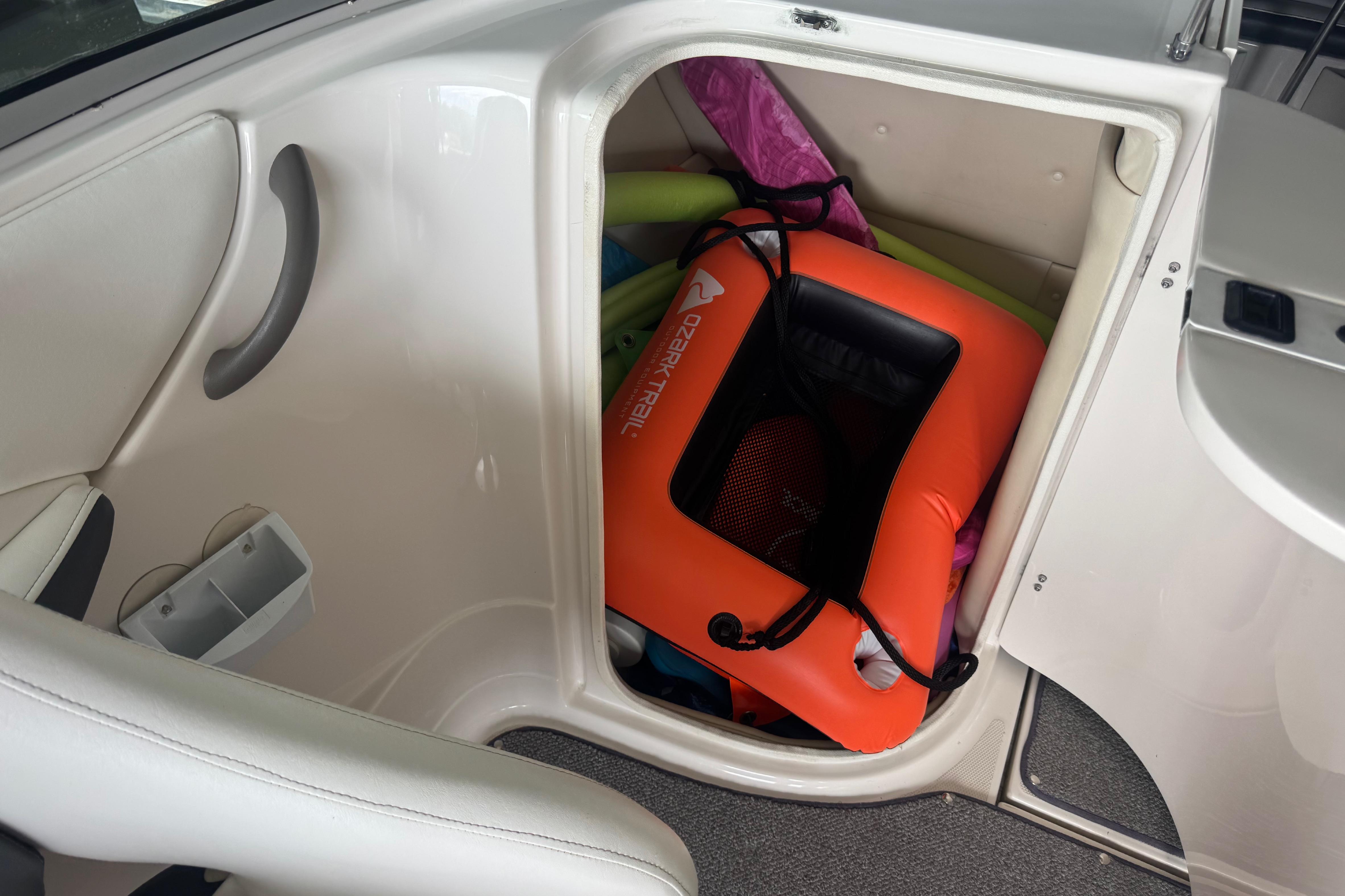 Storage compartment in a 2005 Monterey 248LS Montura Bowrider with life jackets and pool noodles.