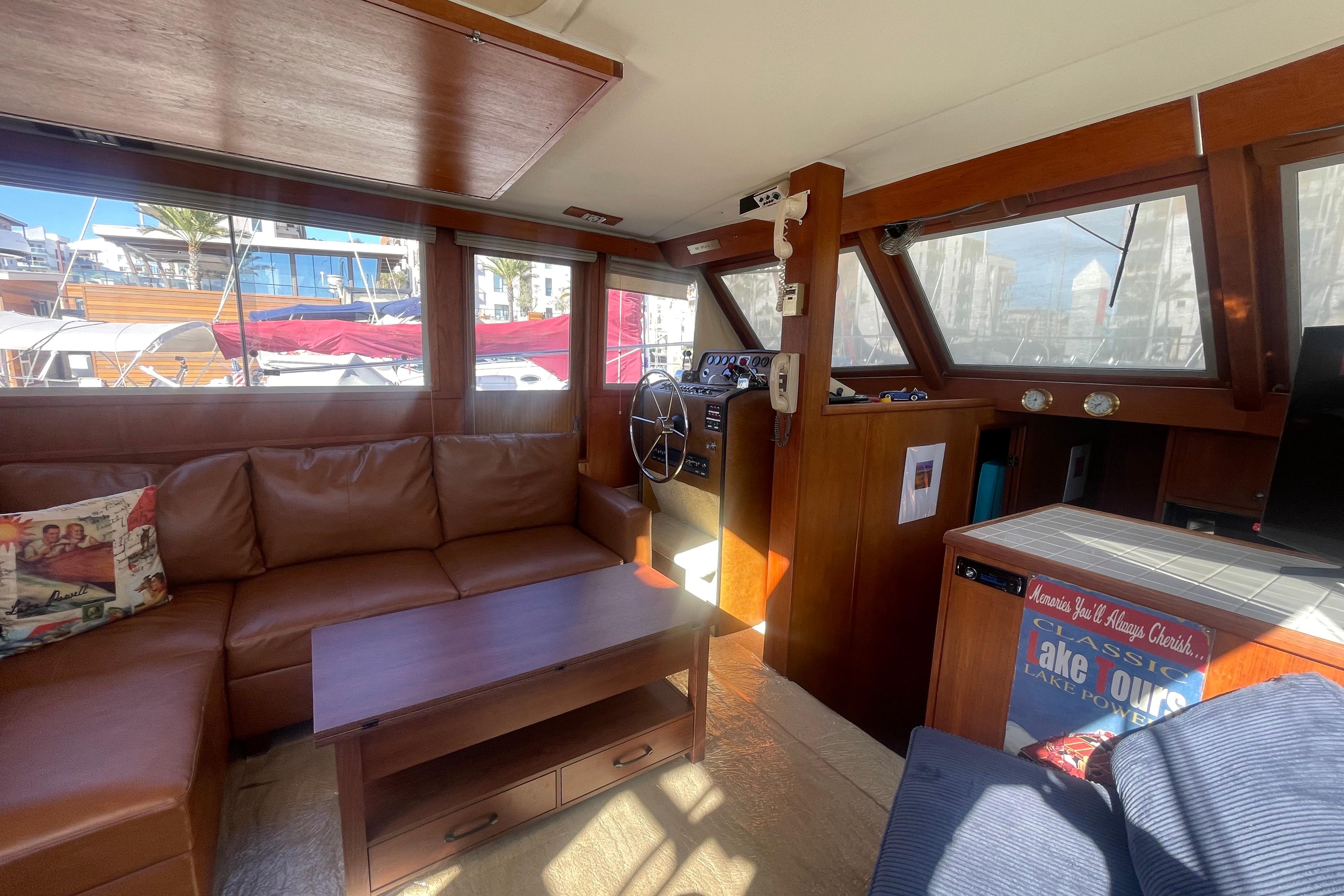 1975 Uniflite Aft Cabin interior with leather seating and wooden helm, docked at marina.