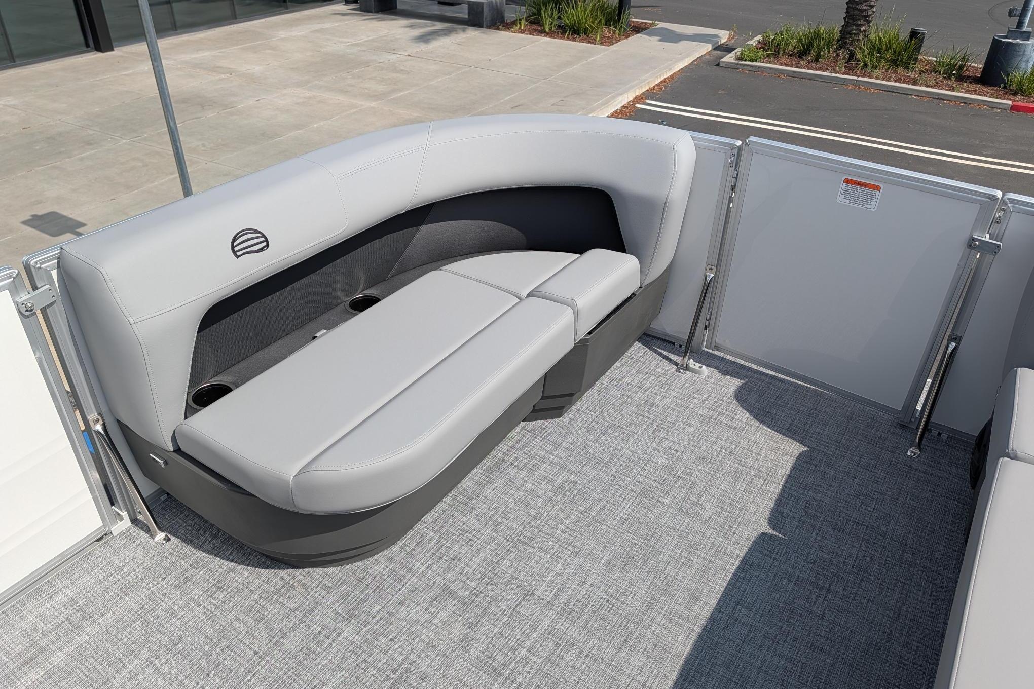 2026 Sun Tracker Party Barge 16 DLX interior with gray seating and cup holders.