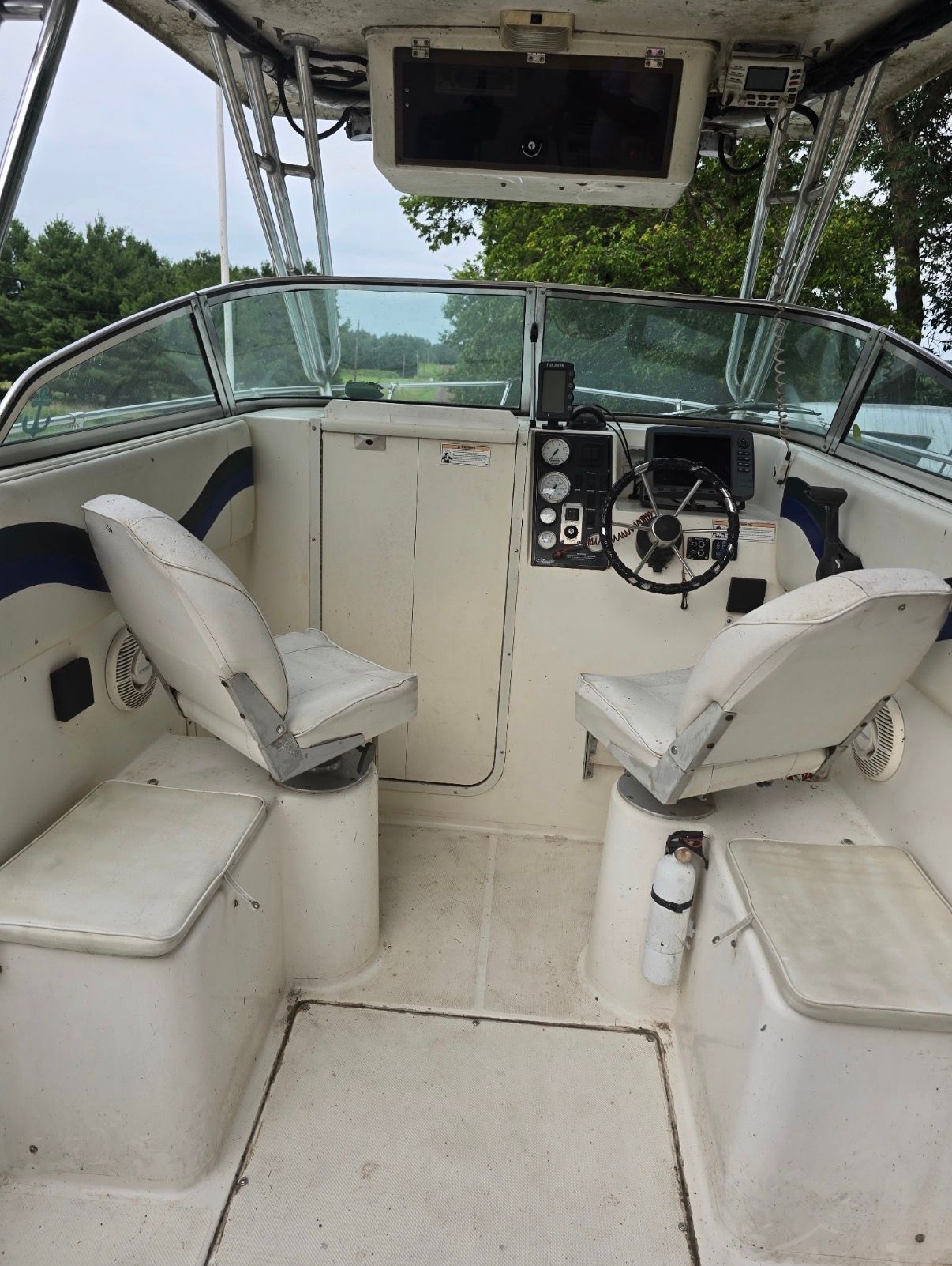 The image shows the cockpit of a 1999 Seaswirl Striper 2100 with two seats and a helm.