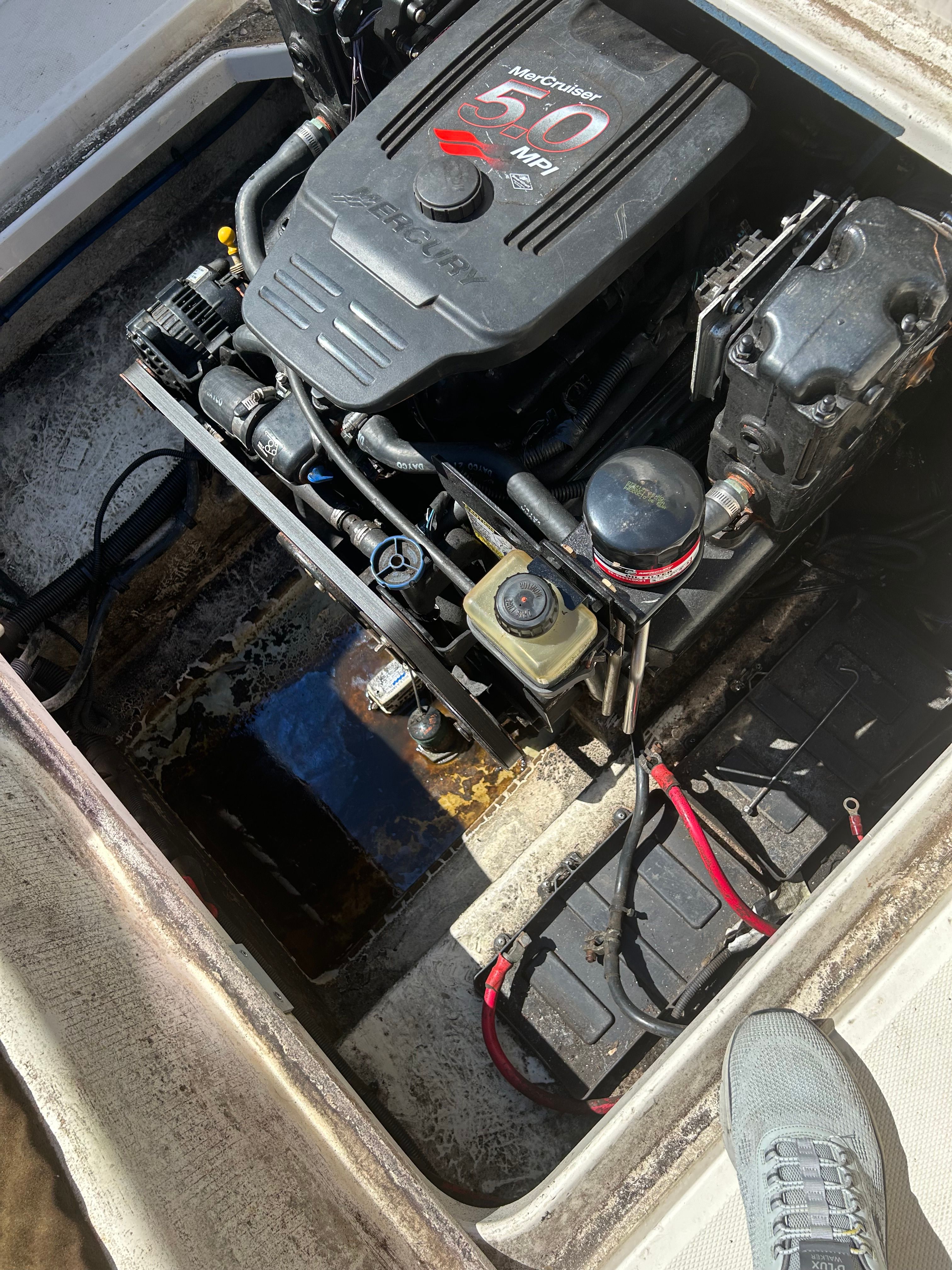 An engine compartment with a MerCruiser 5.0 MPI engine in a Sea Ray 225 Weekender boat.