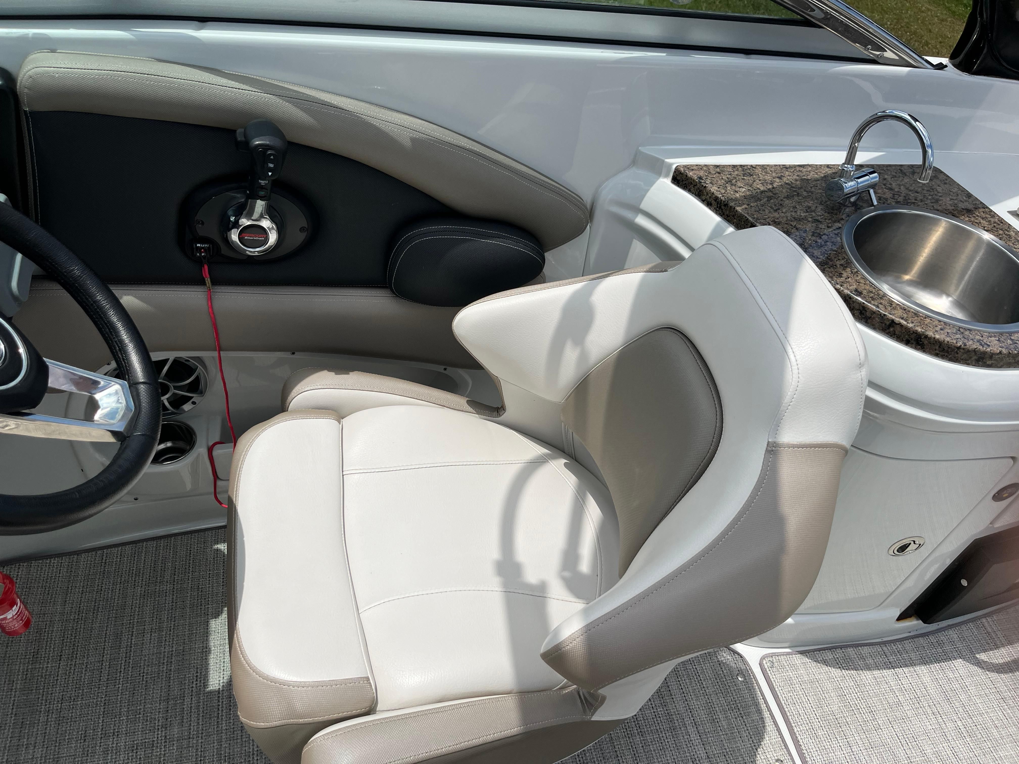 The interior of a 2019 Crownline E 285 with a comfortable seat and a small sink.