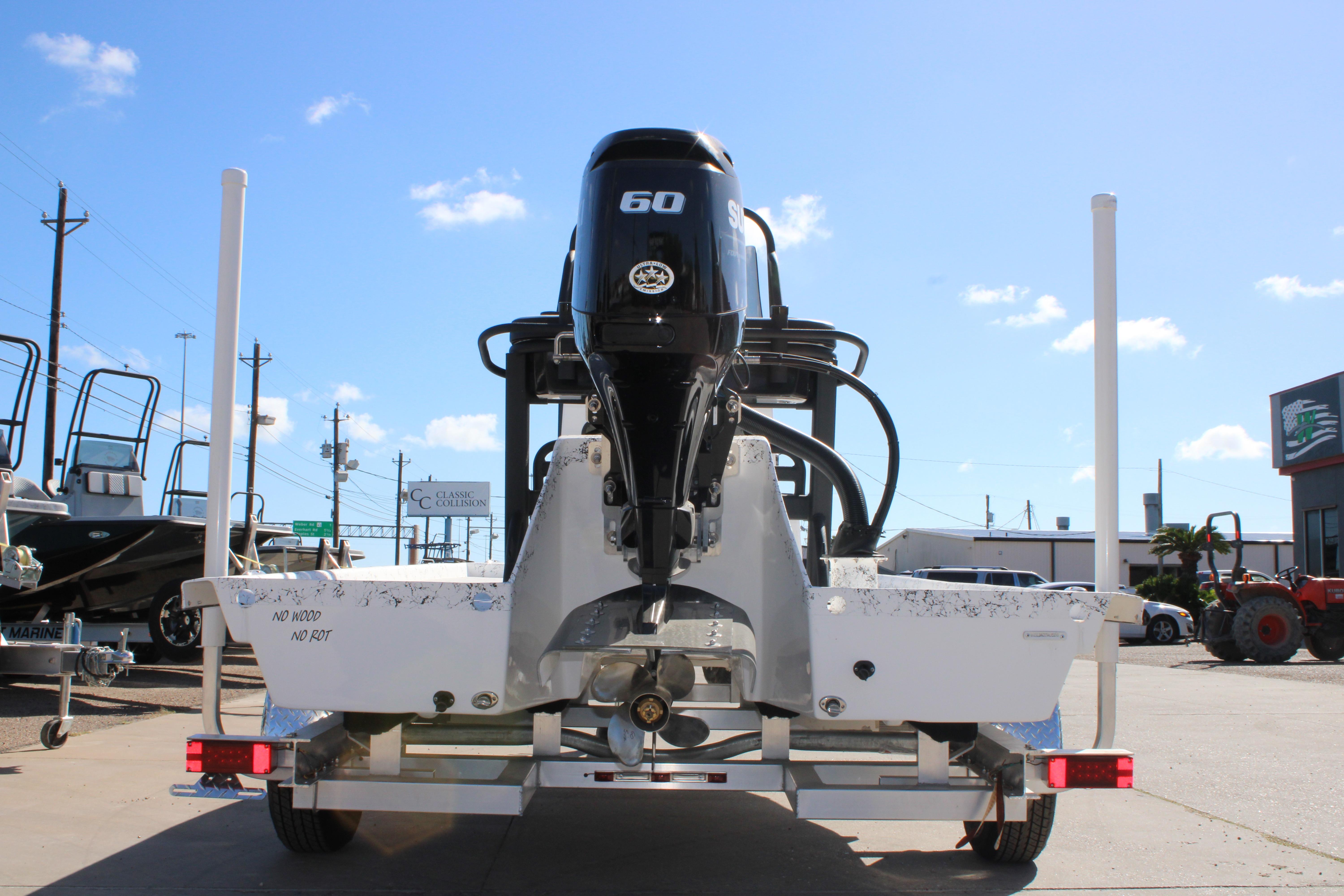 2026 Freedom Boats Chiquita with 60 HP engine on trailer, outdoor display.