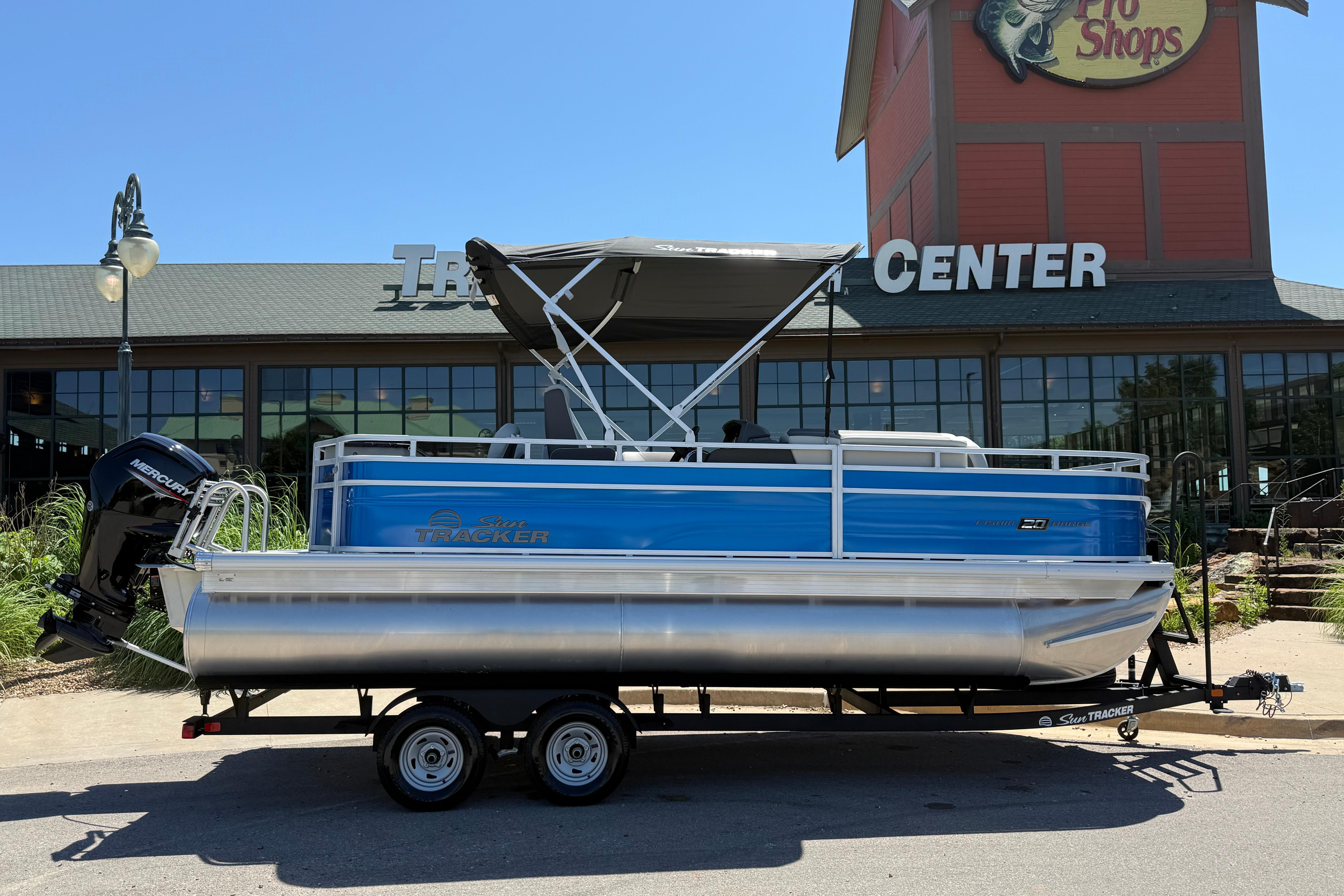 2026 Sun Tracker Fishin' Barge 20 DLX pontoon boat displayed outside a retail center.
