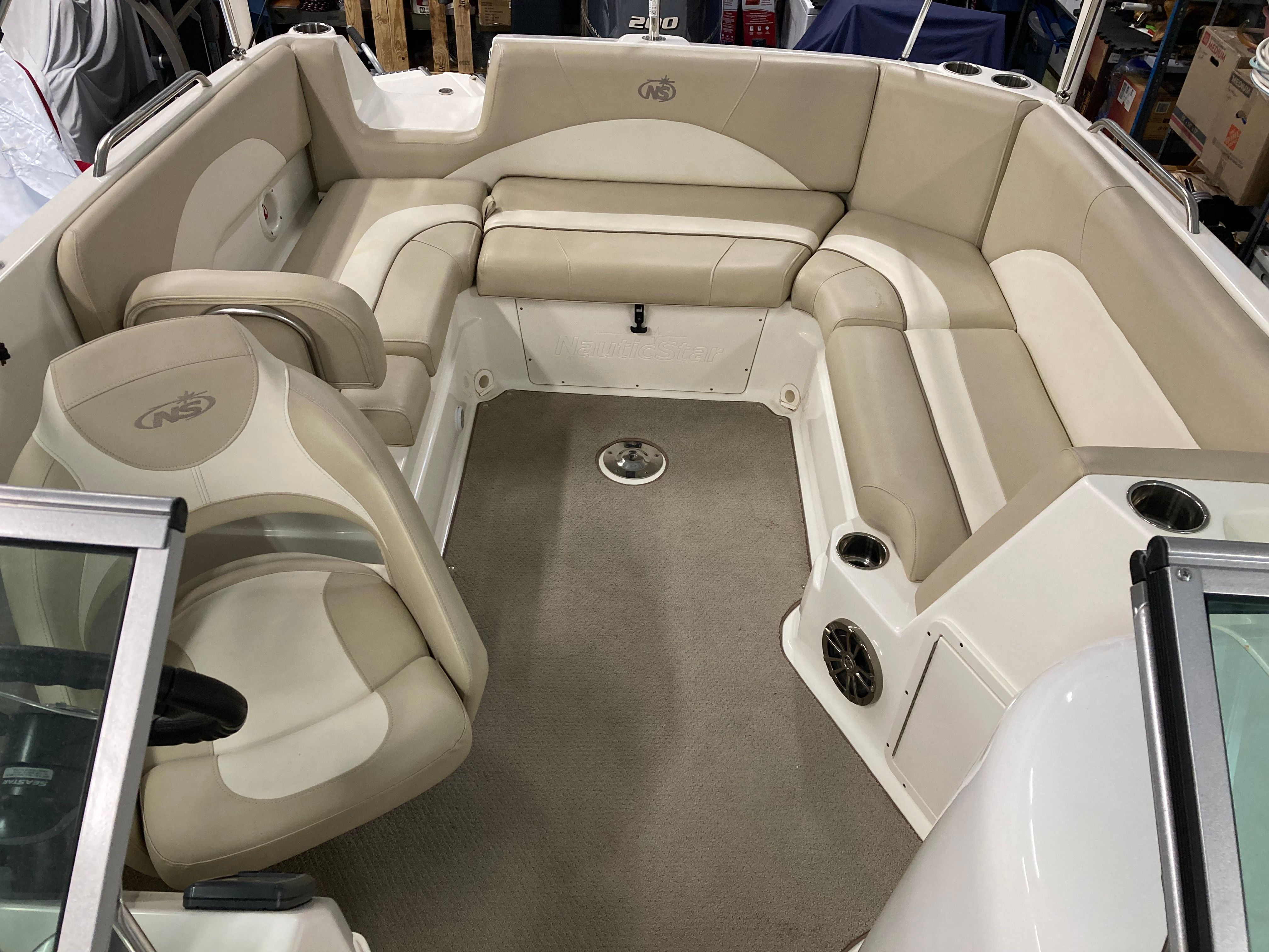 Interior of a 2016 Custom 223 DC boat with beige upholstery.