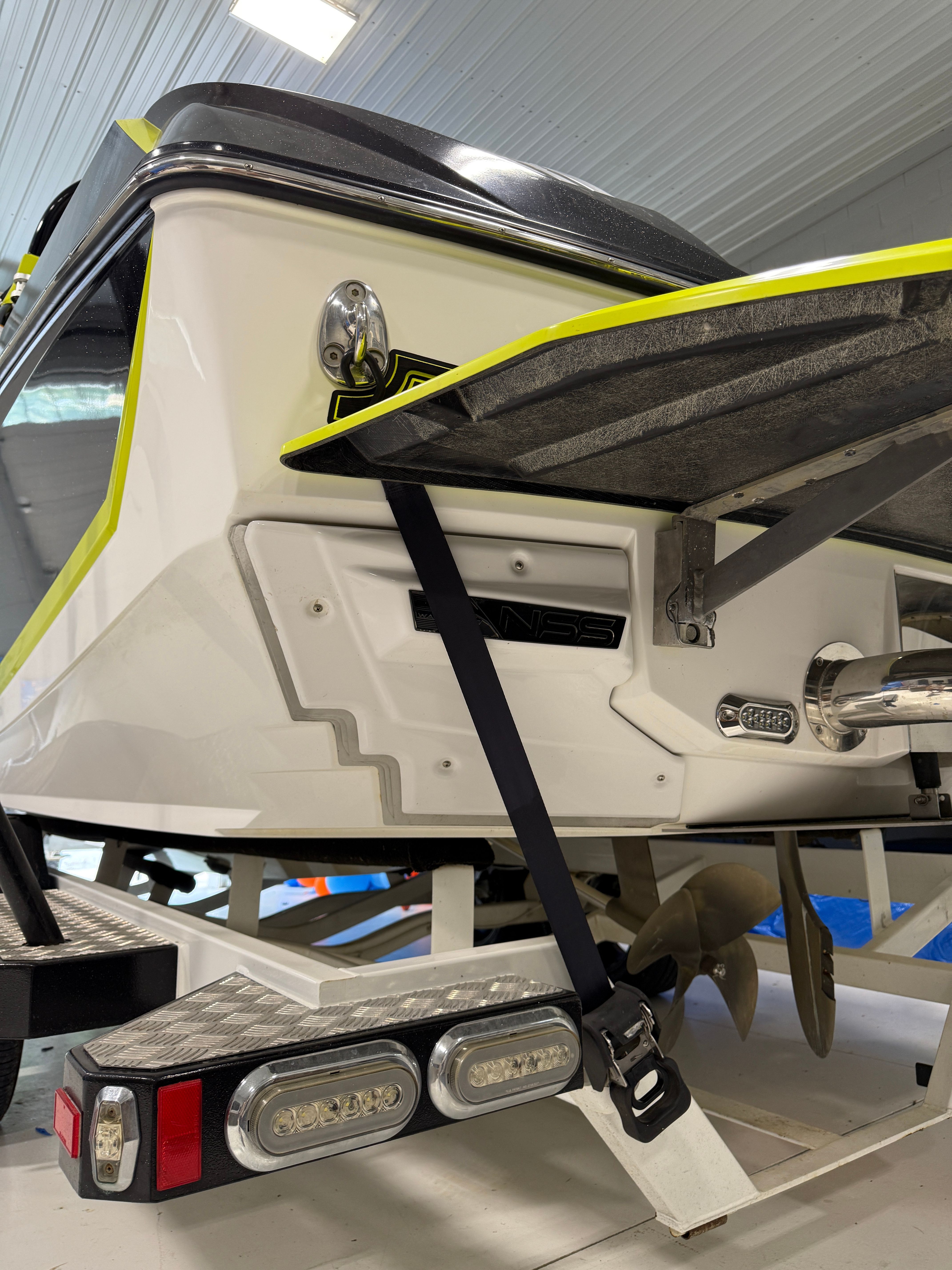 The image shows the stern of a 2016 Nautique Super Air Nautique G23 boat in a warehouse.