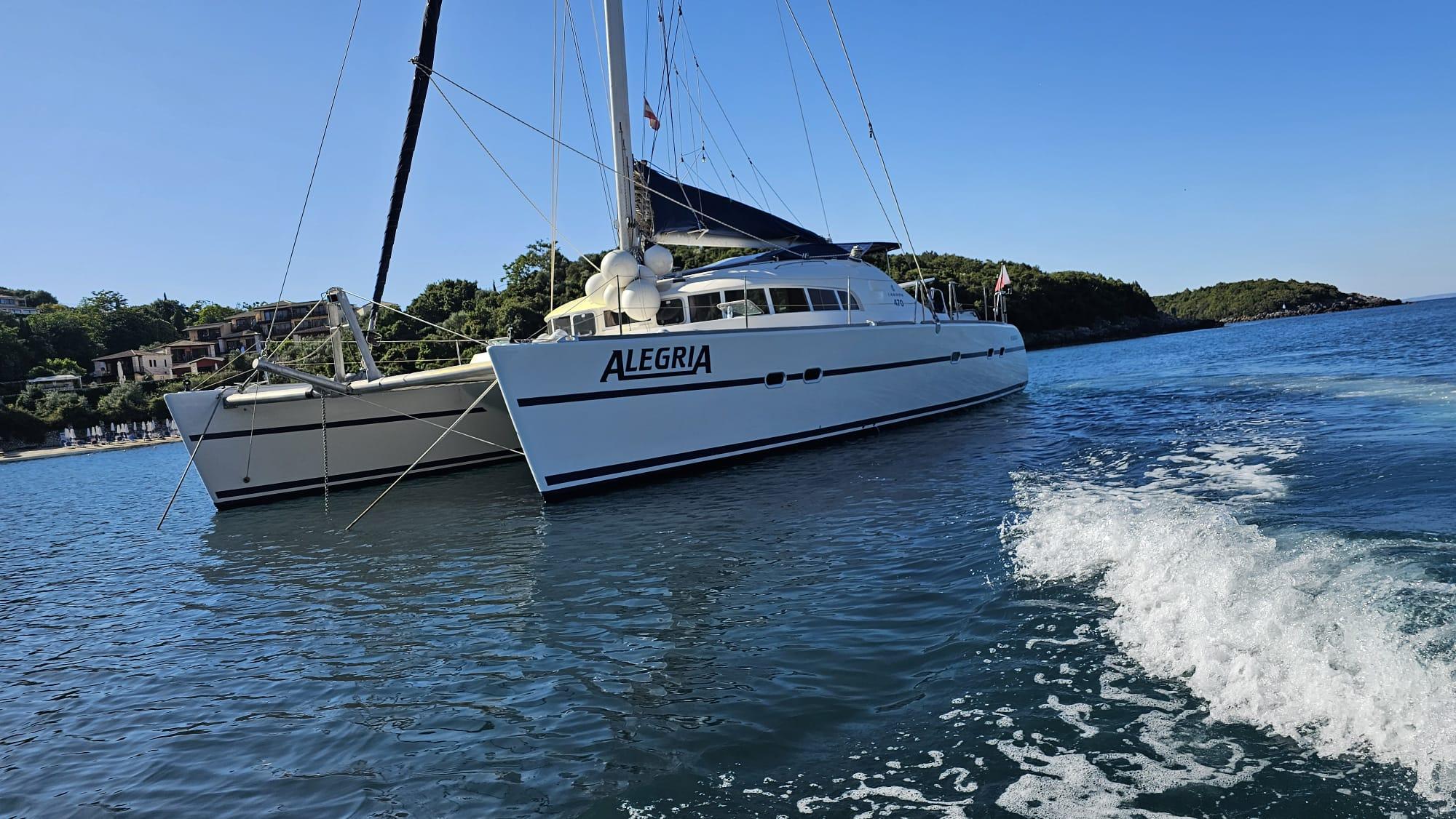 Lagoon 470 catamaran from 1998 named Alegria, anchored in calm blue waters.