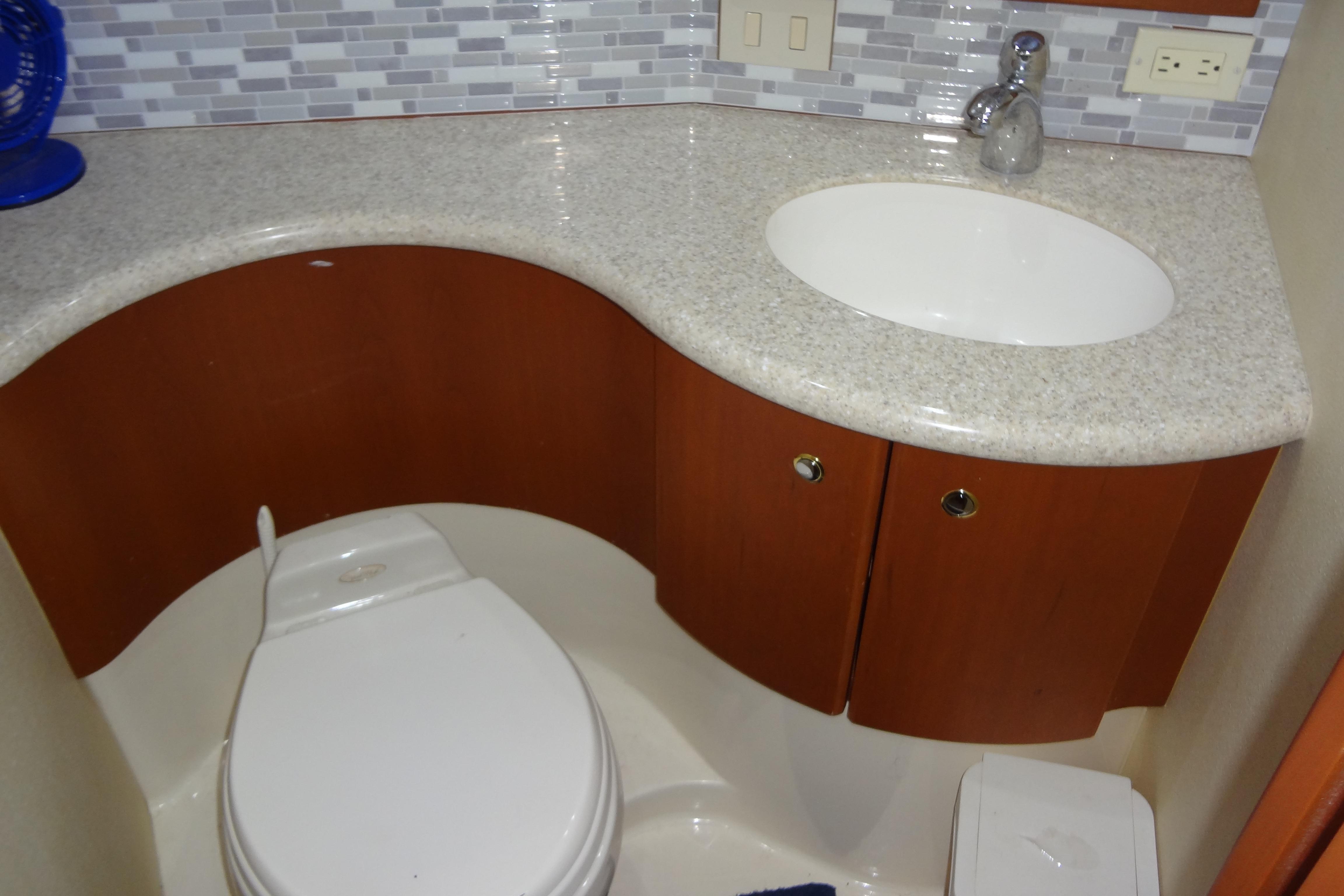 Bathroom interior of 2005 Silverton 34 Convertible yacht with sink and toilet.