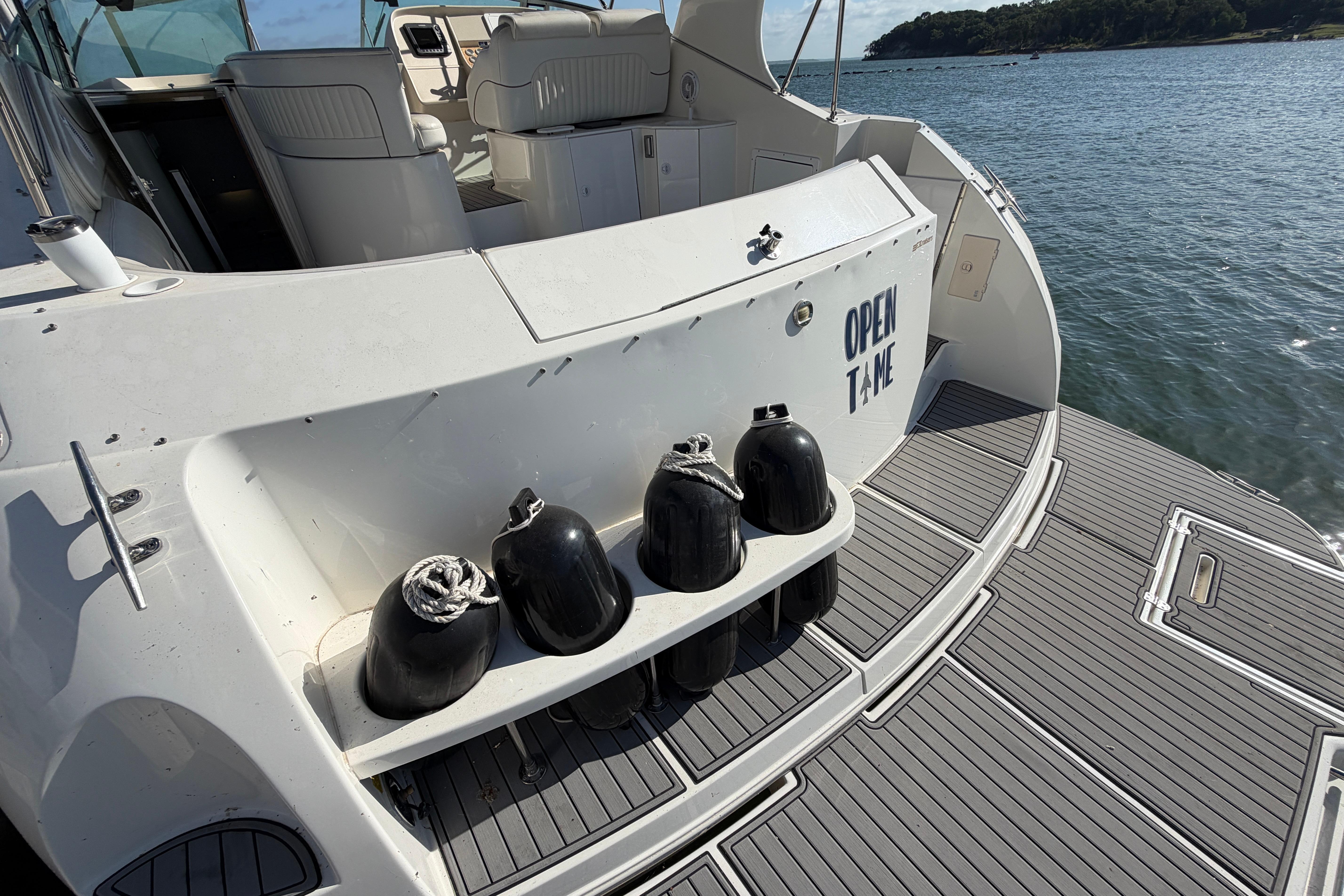 1997 Cruisers 3575 yacht stern with fenders, docked by the water.
