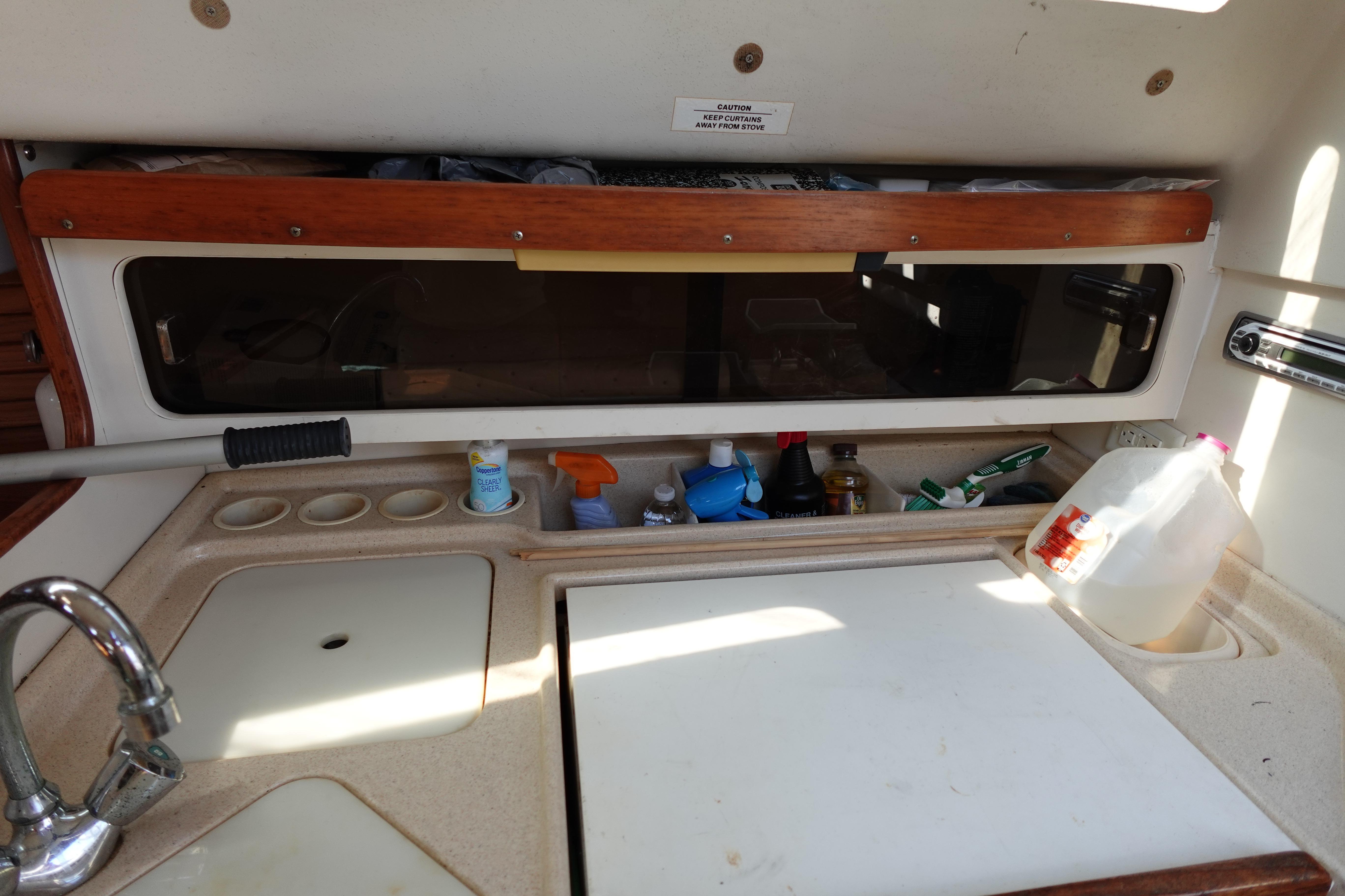 Interior of a 1997 Catalina 28 sailboat kitchen with sink and storage.