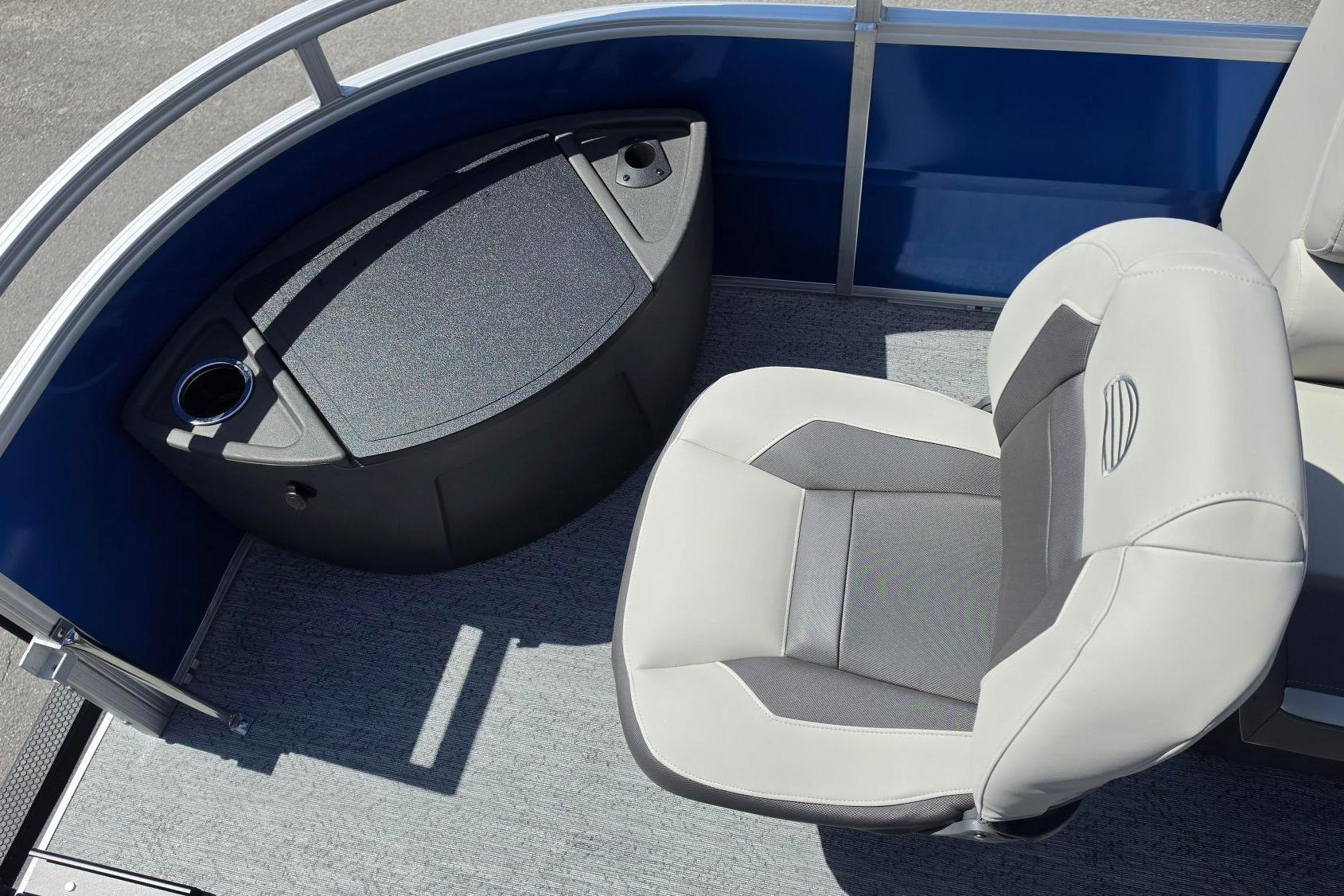2026 Sun Tracker Fishin' Barge 20 DLX interior with cushioned seating and storage compartment.