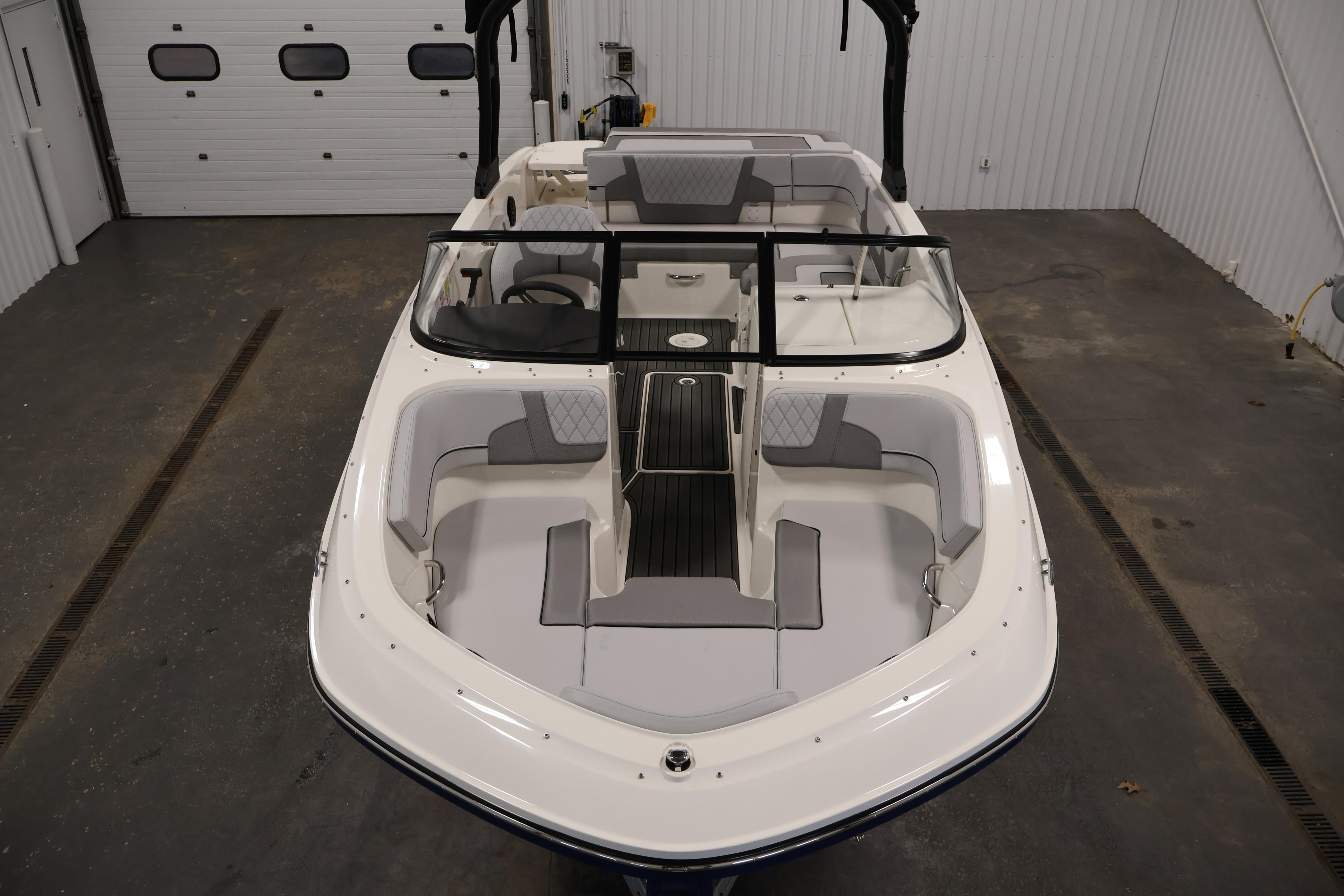 2026 Bayliner VR6 Bowrider I/O in a garage, showcasing sleek design and spacious seating.