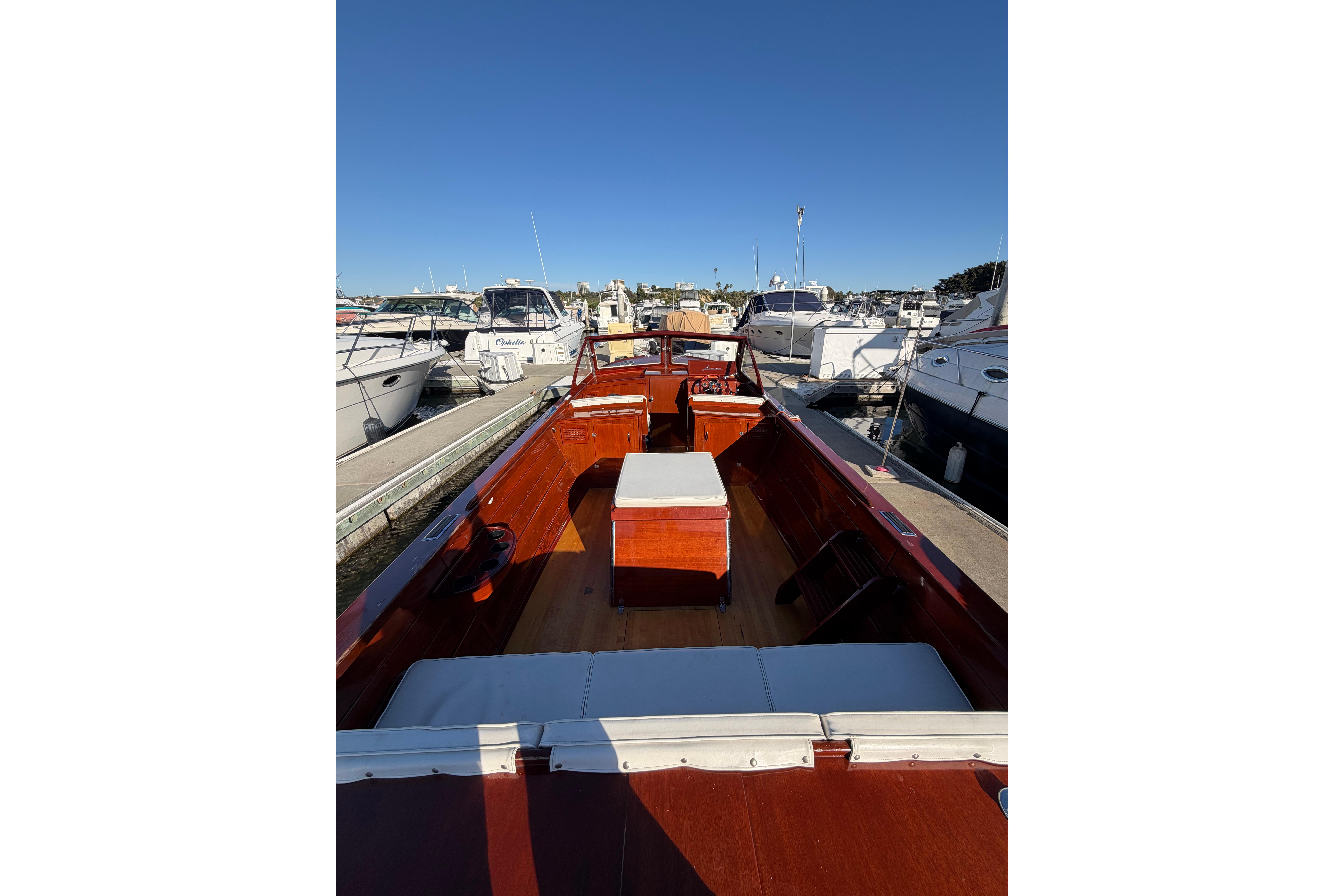 1964 Lyman 25 Sleeper boat docked at marina, showcasing classic wooden design.