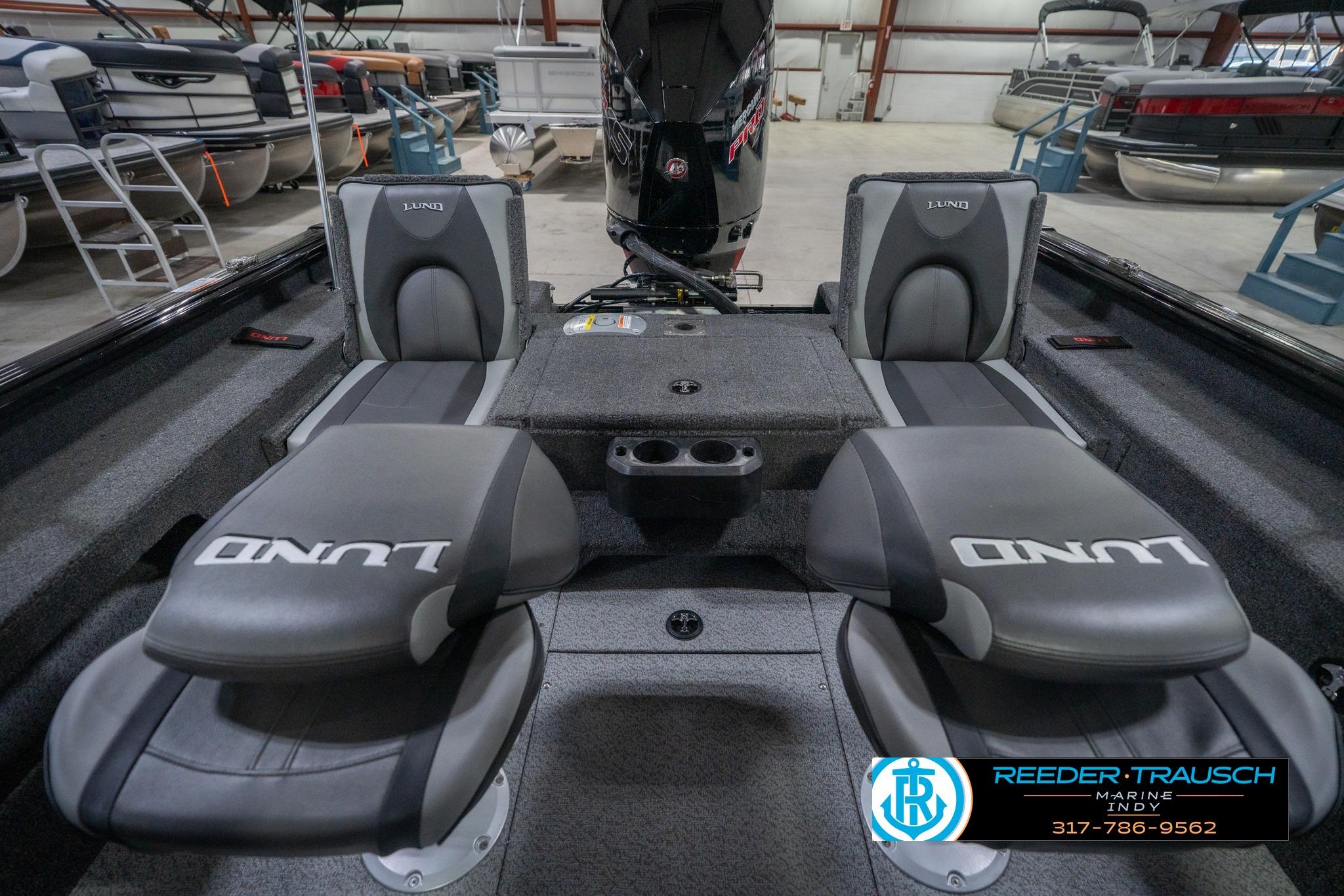 2026 Lund 2075 Impact XS boat interior with seating and storage in a showroom.