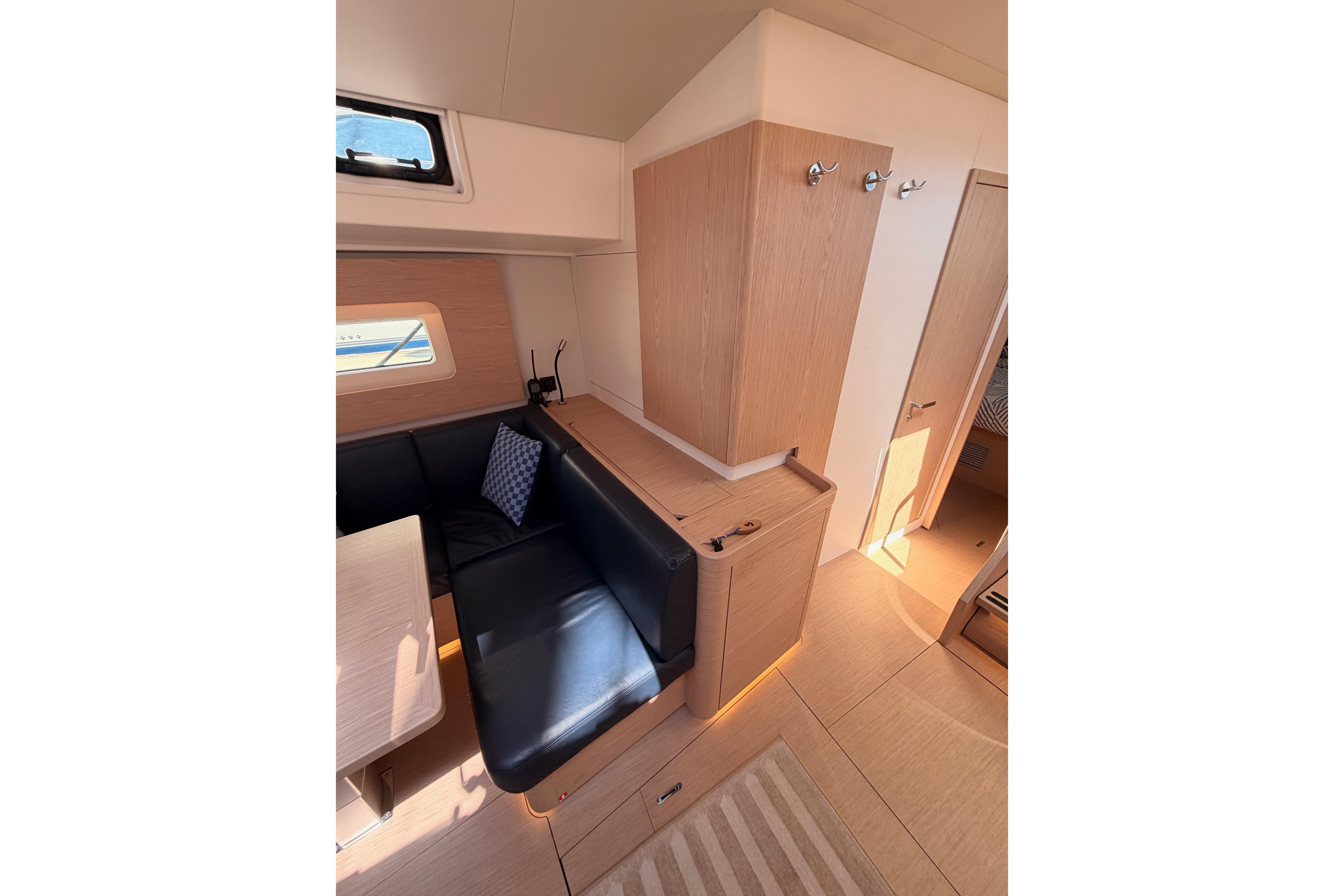 Interior of 2022 Beneteau Oceanis Yacht 54, featuring sleek wood finishes and comfortable seating.
