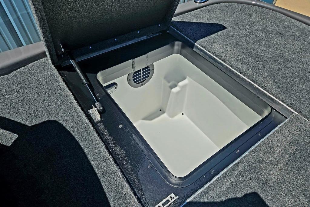 Open storage compartment in 2026 Skeeter ZXE20 boat, featuring carpeted interior and hydraulic lift.
