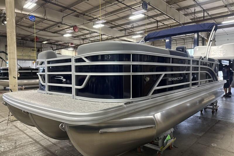 2026 Bennington 23 SSRSF pontoon boat in a warehouse, showcasing sleek design and modern features.