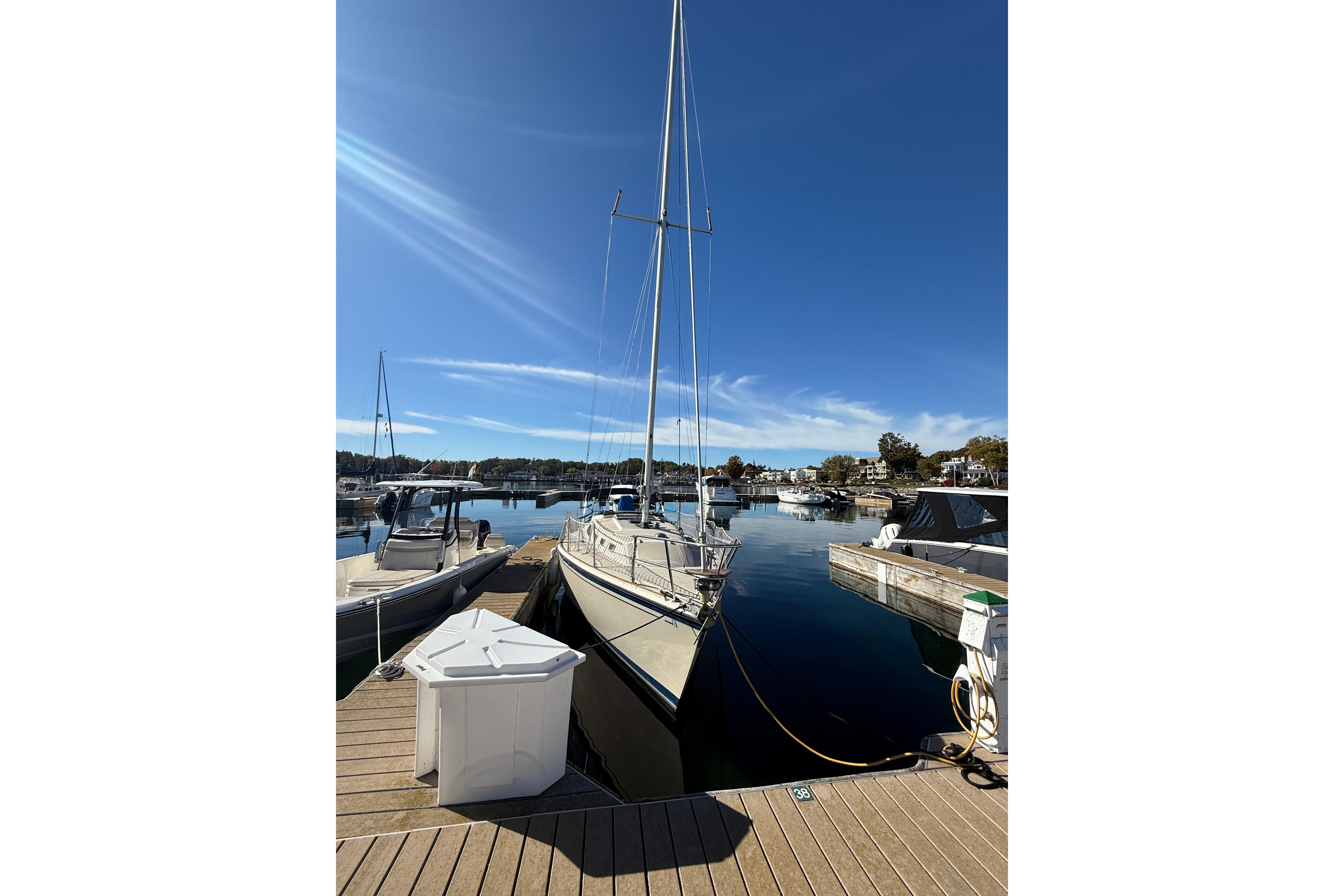 1983 O'Day 34 sailboat docked at a marina under clear blue skies.