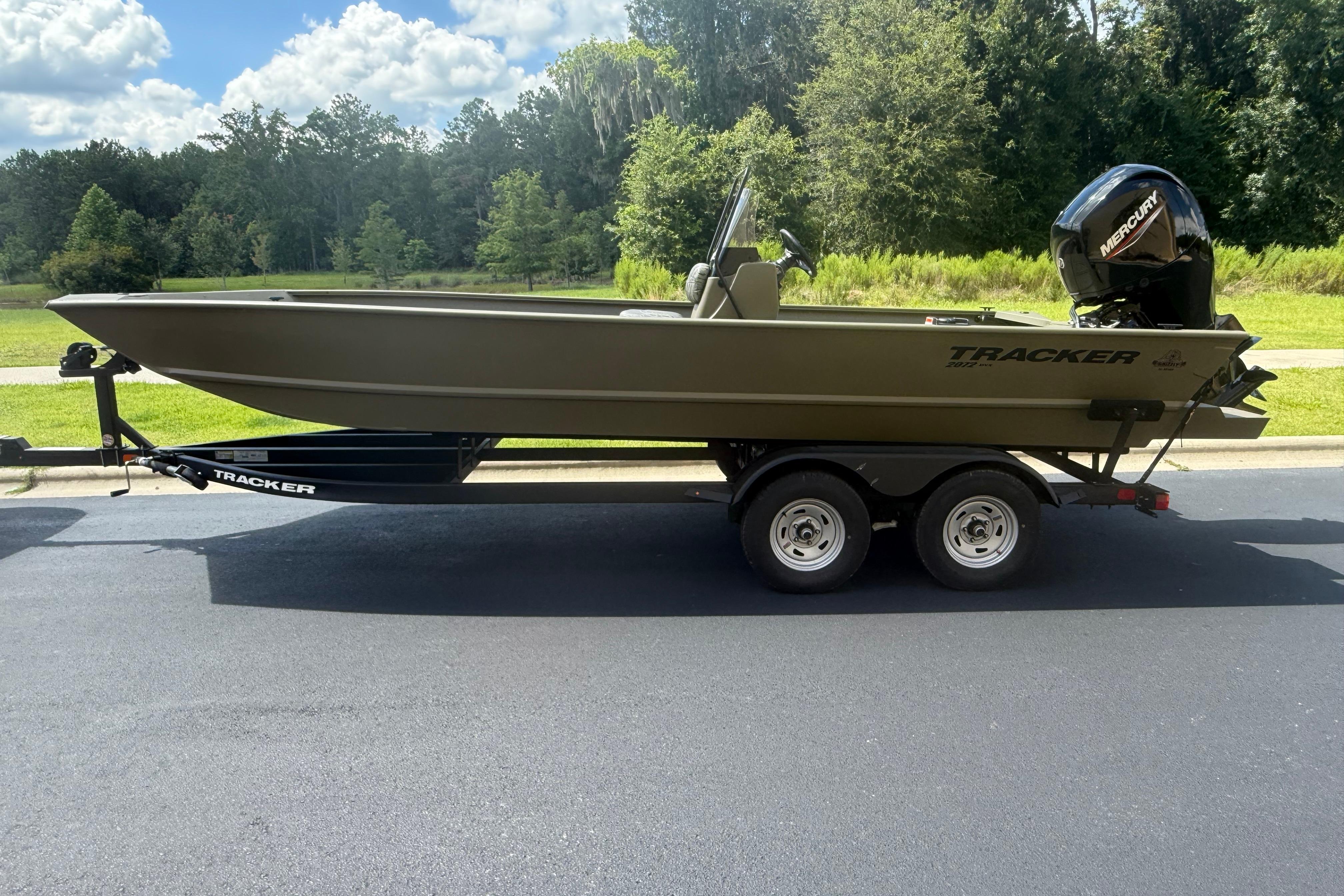 2026 Tracker Grizzly 2072 CC boat on trailer, parked outdoors on a sunny day.
