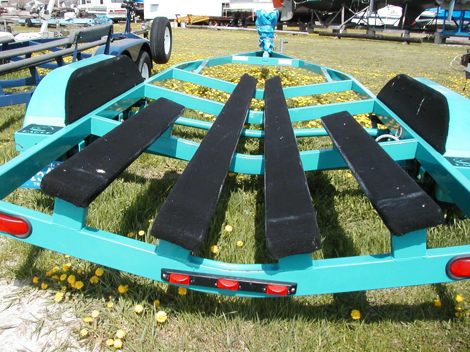Boat trailer for 1994 Sea Ray 230 Sundancer on grassy field.