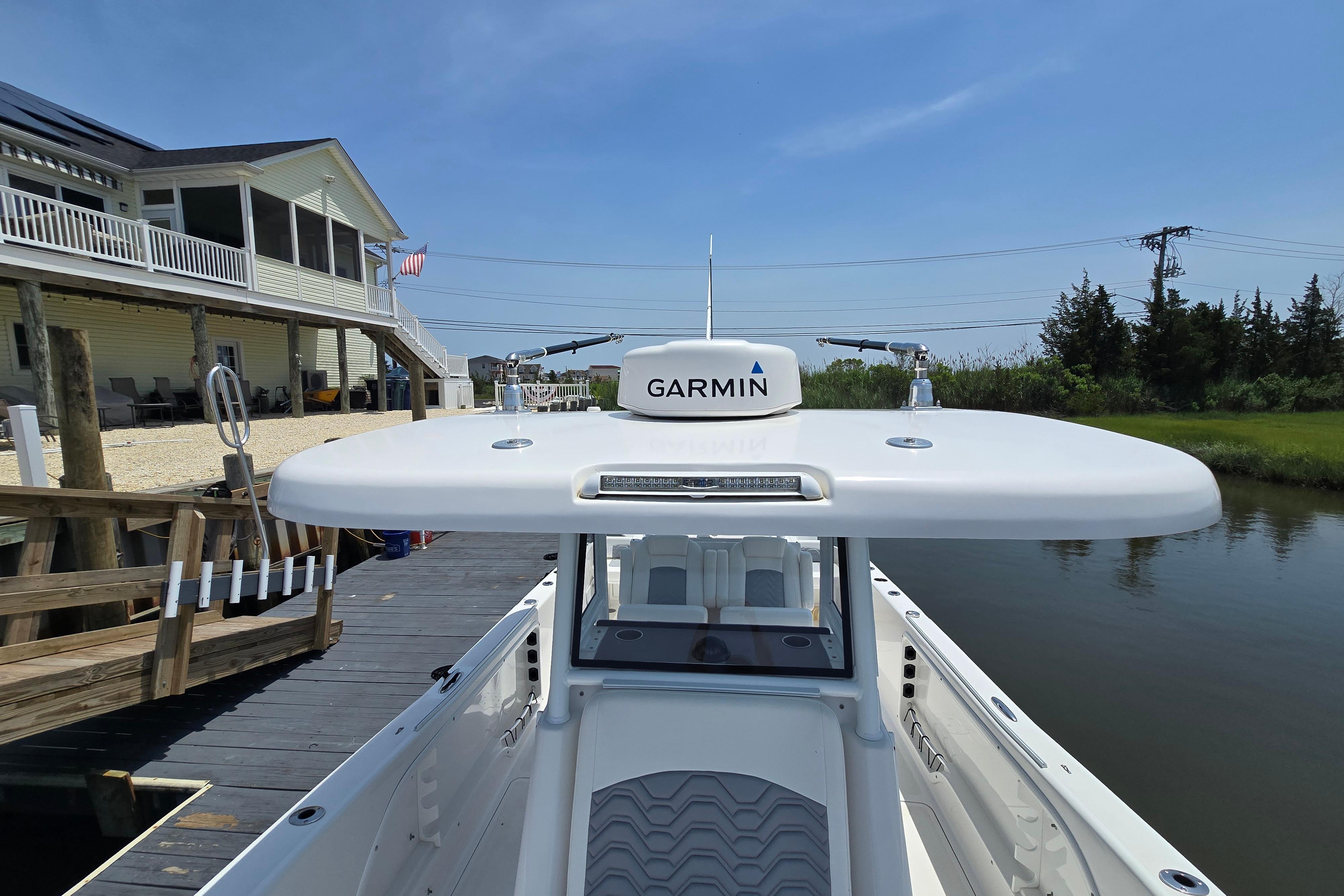 2021 Twin Vee 280 GFX CC boat docked, featuring Garmin equipment, near waterfront home.
