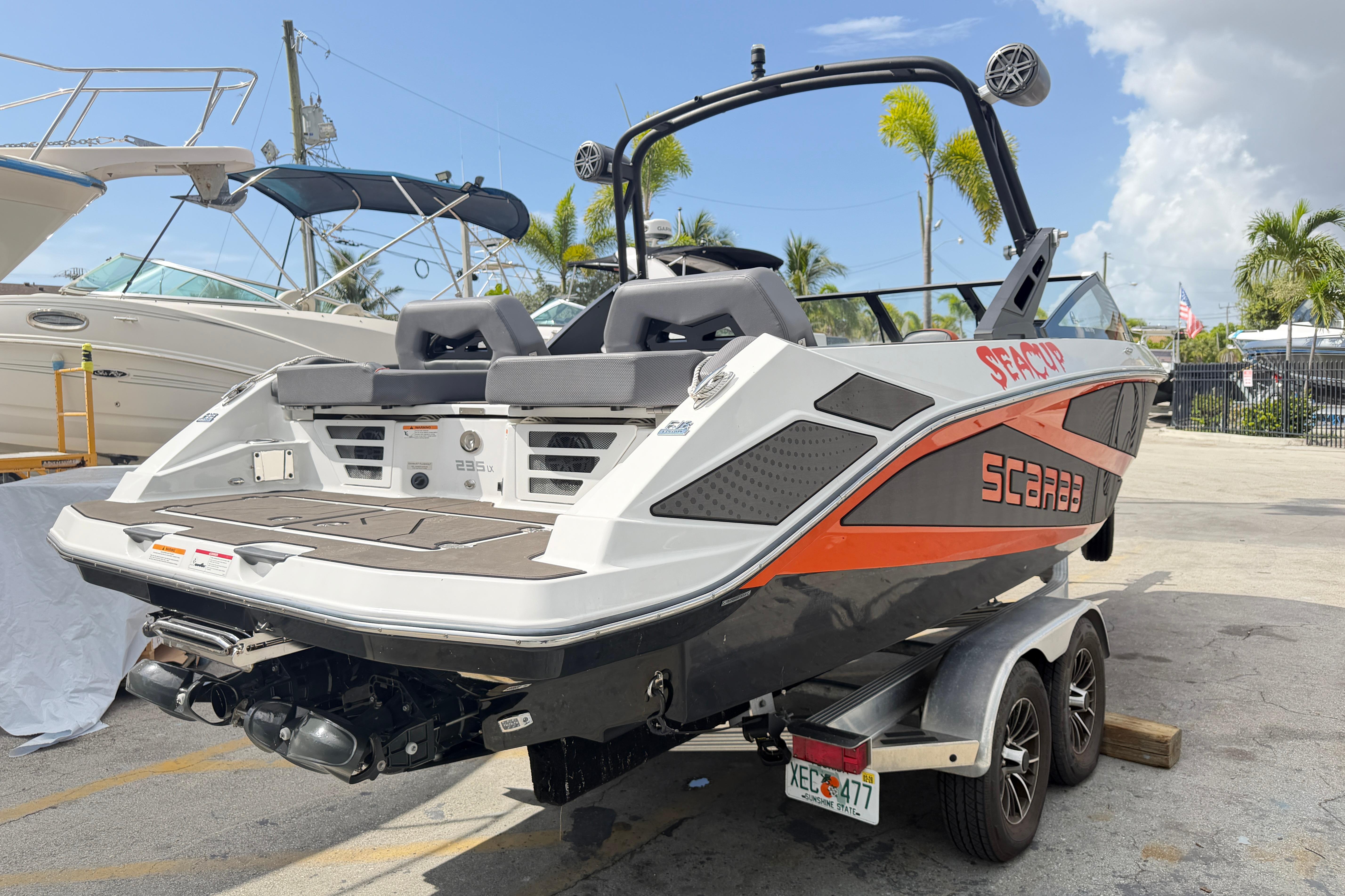 2026 Scarab 235 LX boat on trailer, featuring sleek design and vibrant orange accents.