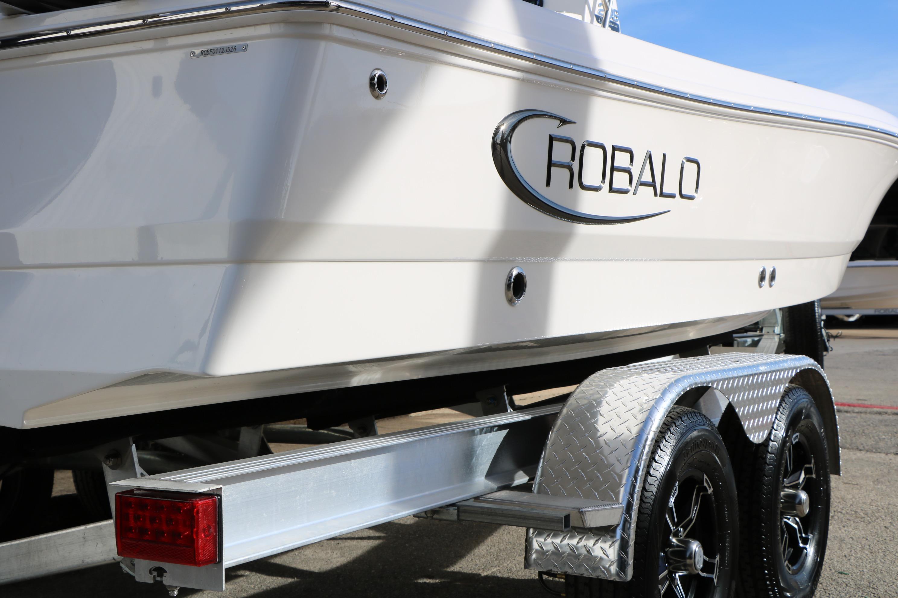 2026 Robalo 206 Cayman boat on trailer, showcasing sleek design and branding.